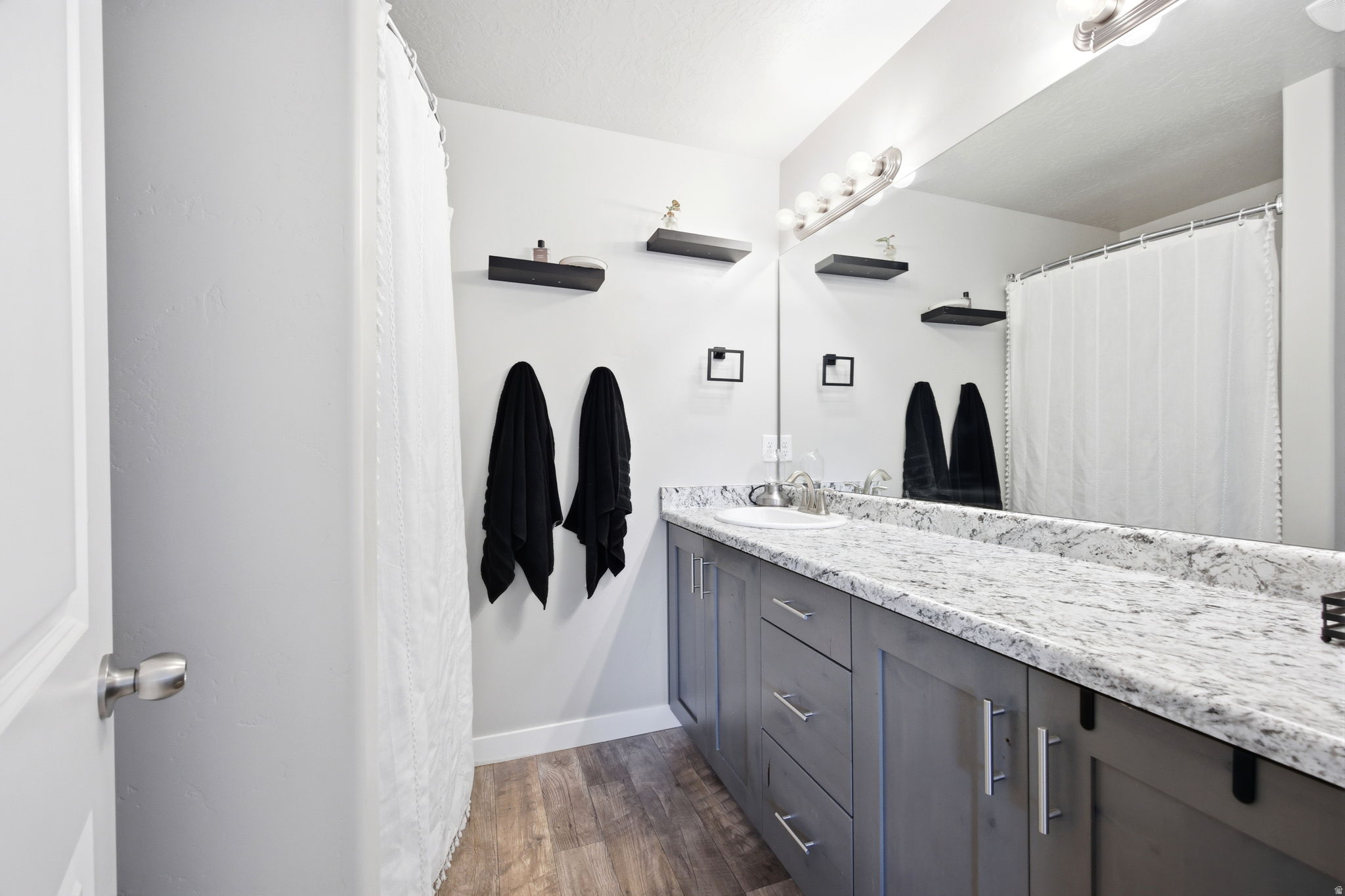 Primary Bathroom featuring a single vanity with gray cabinetry, a white countertop, and a built-in sink