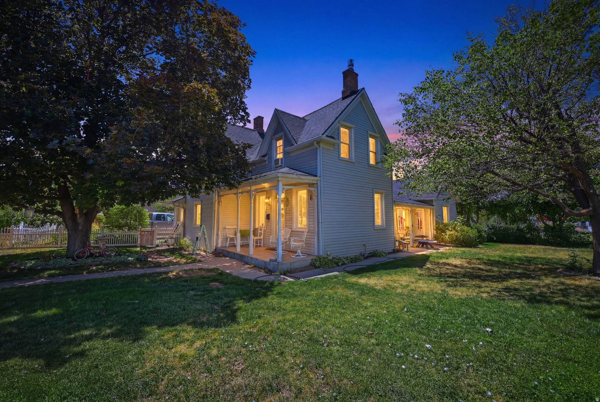 Two-story residence featuring light-colored siding, a covered porch, and a dormer window