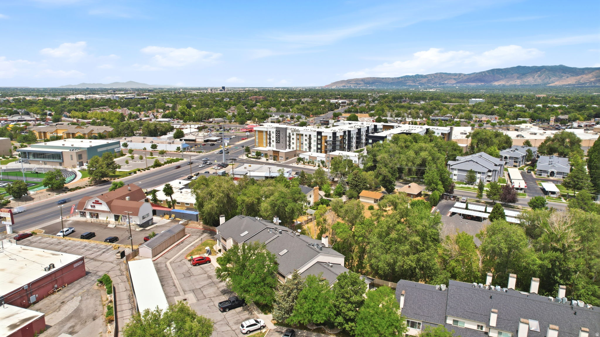 Aerial perspective showcasing a mixed-use neighborhood with established residential structures and commercial buildings