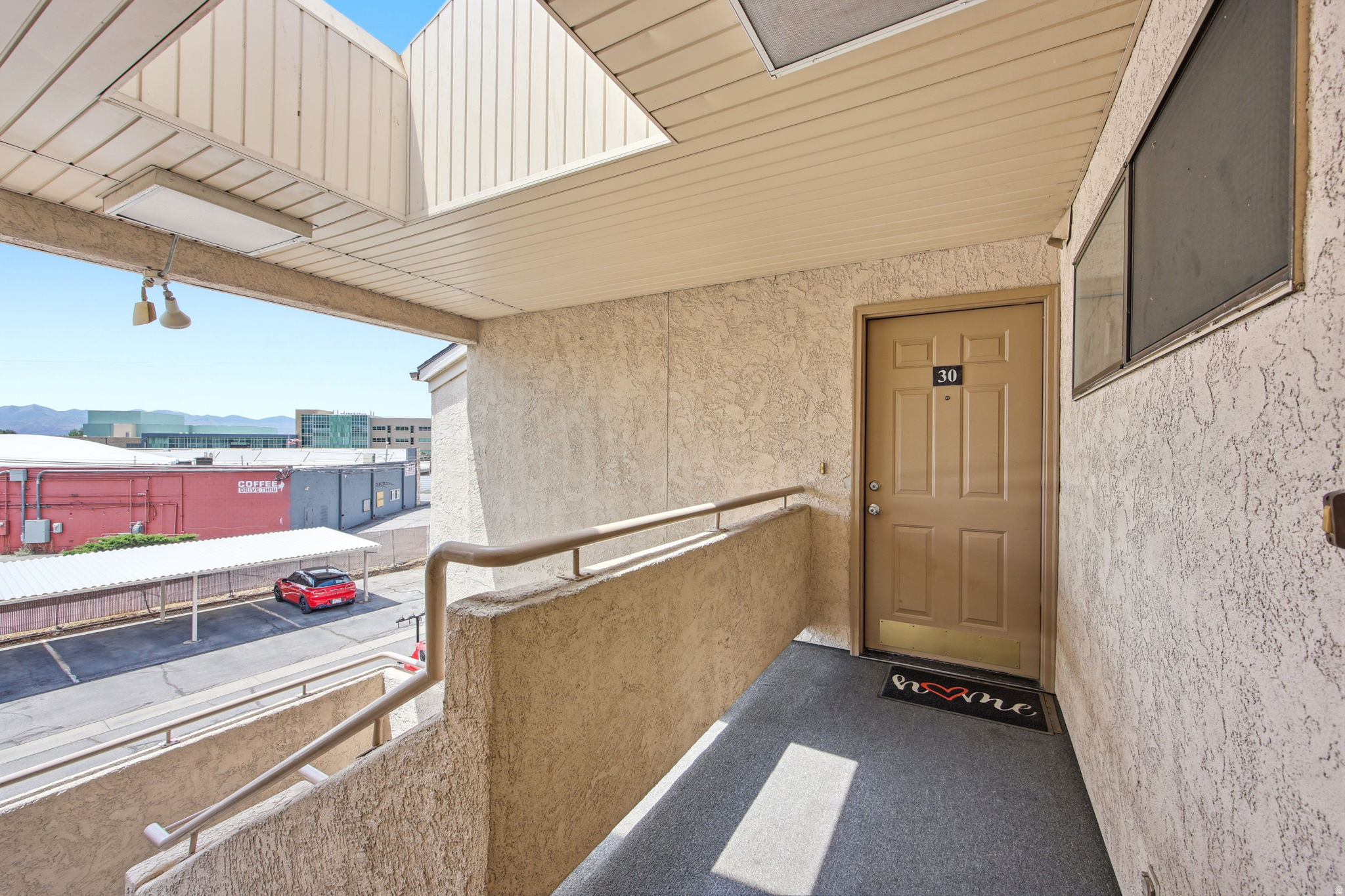 Private entry with neutral-toned door and textured stucco exterior