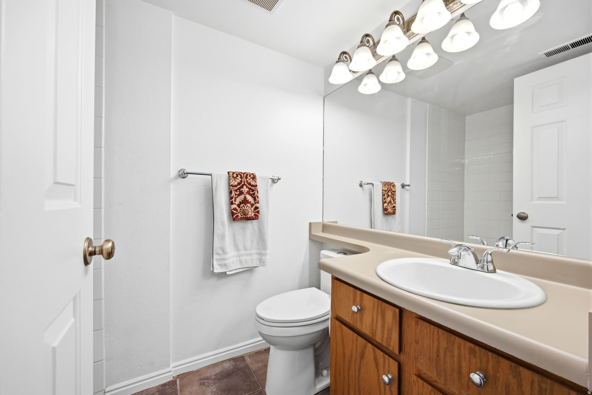 Bathroom vanity featuring a light-colored countertop with an integrated sink and chrome faucet