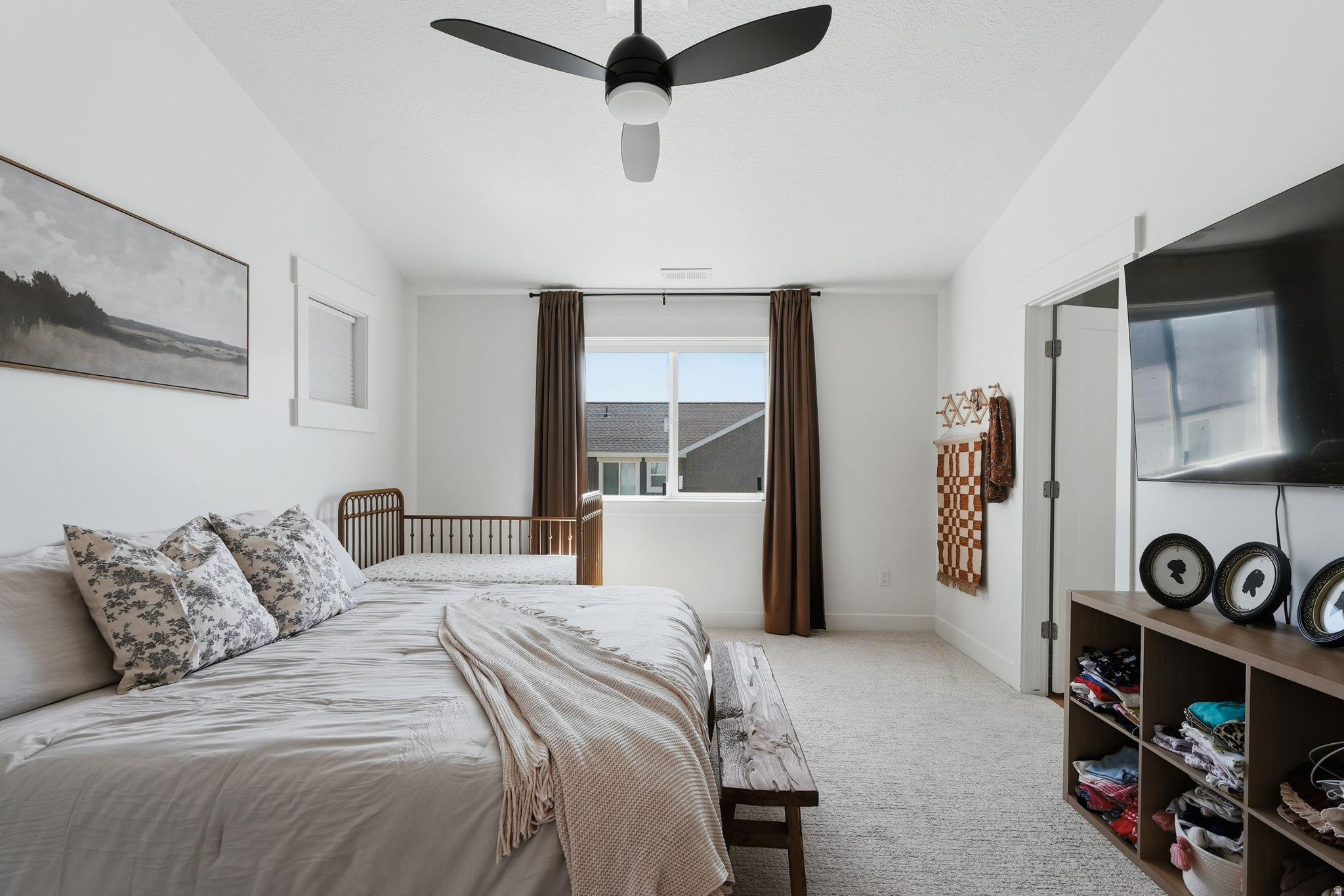 Bedroom featuring light-colored carpeting, white walls, and a modern ceiling fan