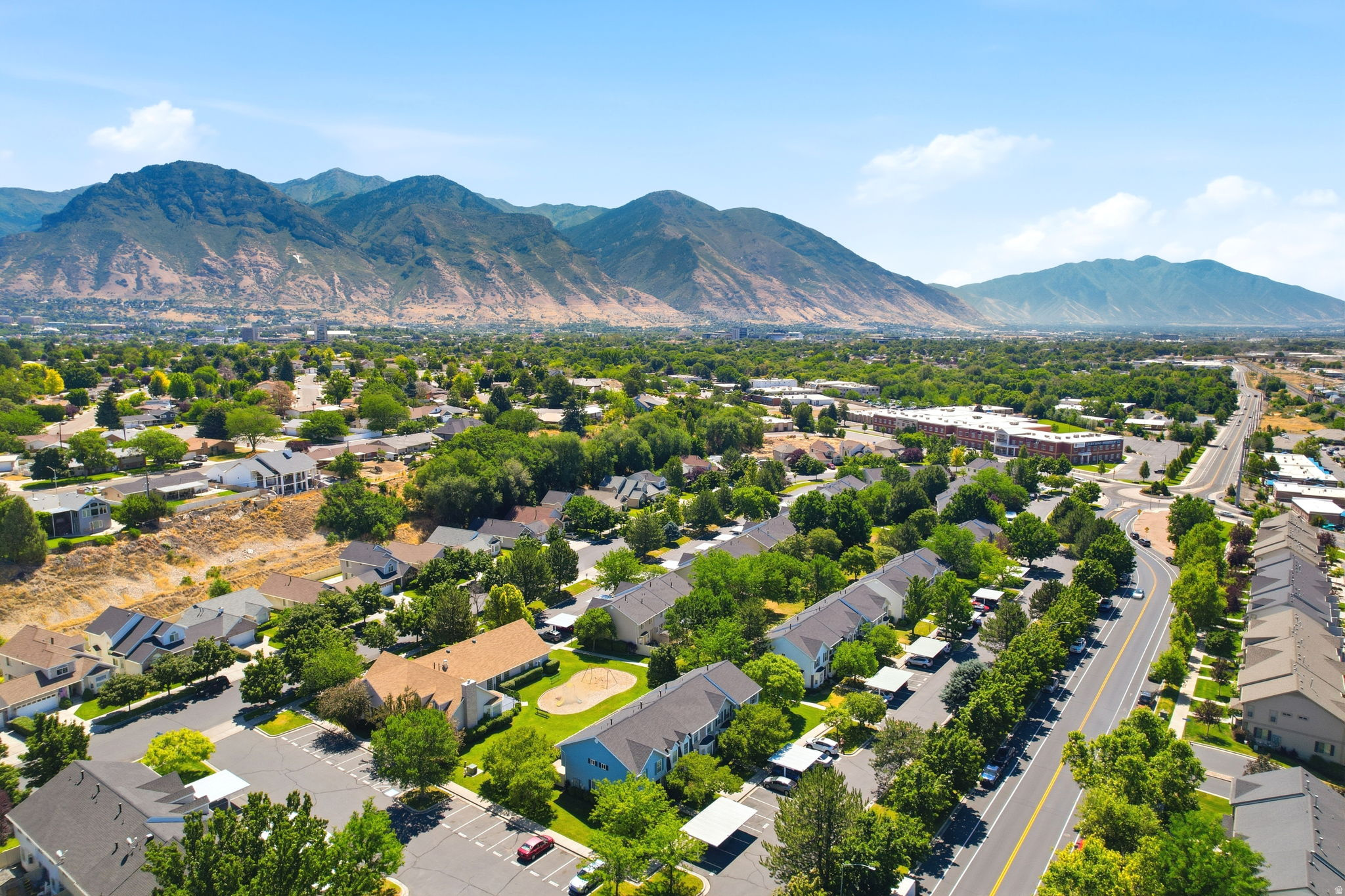 Expansive aerial perspective showcasing a residential community nestled against a mountainous backdrop