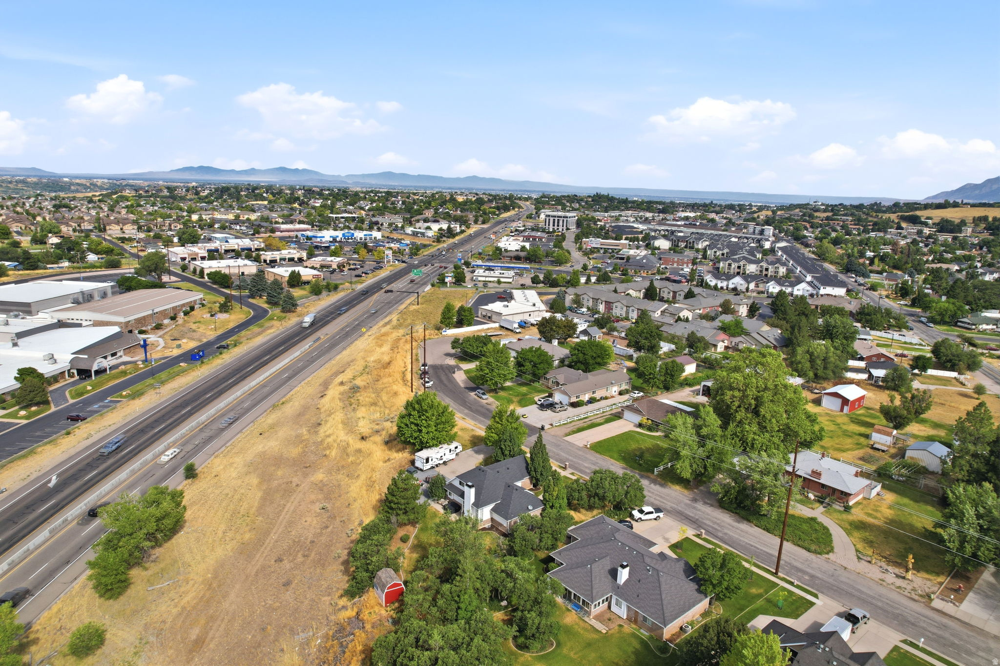 Expansive aerial perspective showcasing a broad urban landscape with commercial structures and residential areas