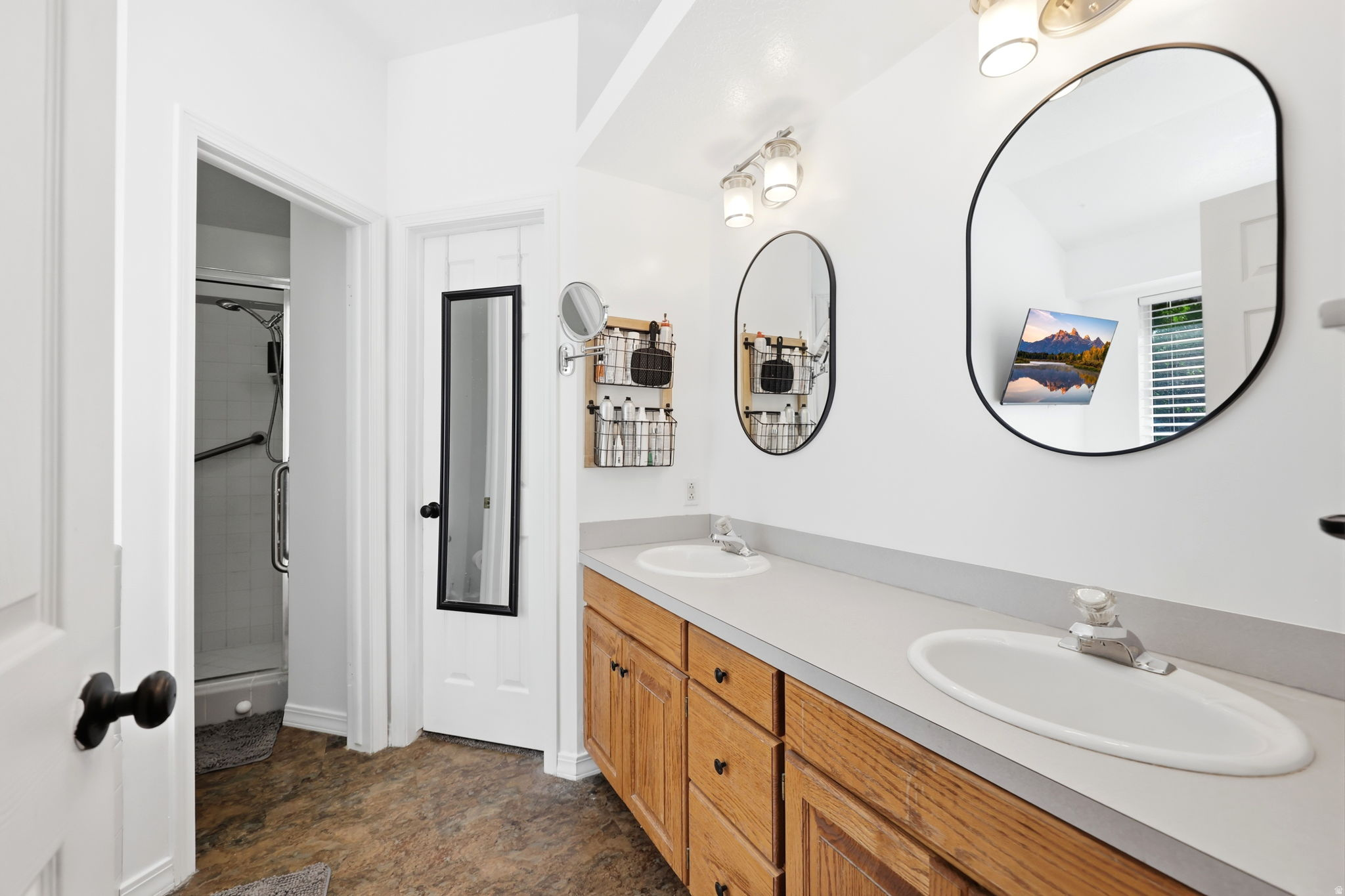 Bathroom featuring a double vanity with wood cabinetry and light countertops