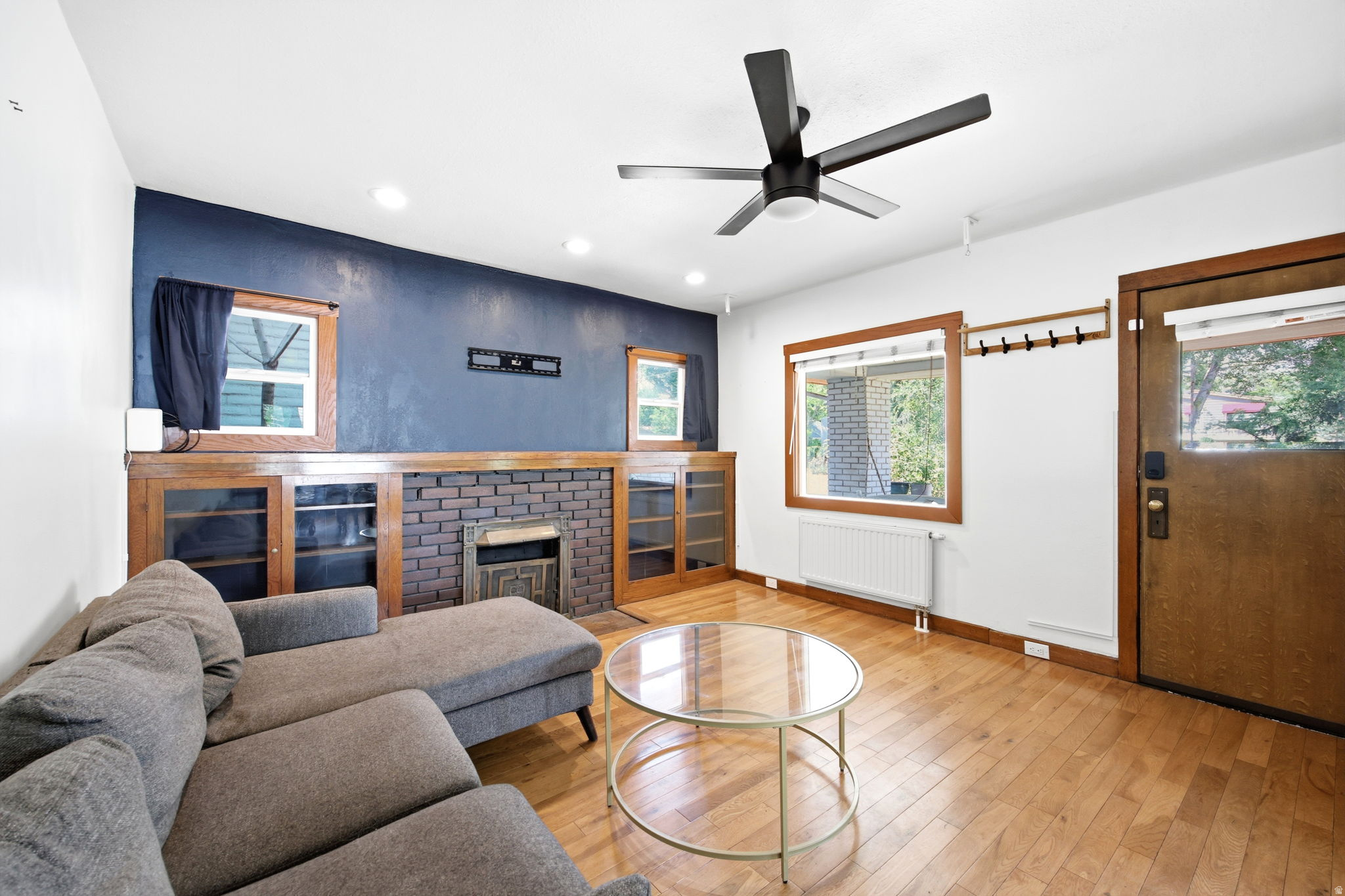 Living space featuring wood-finish flooring, a contemporary ceiling fan, and recessed lighting