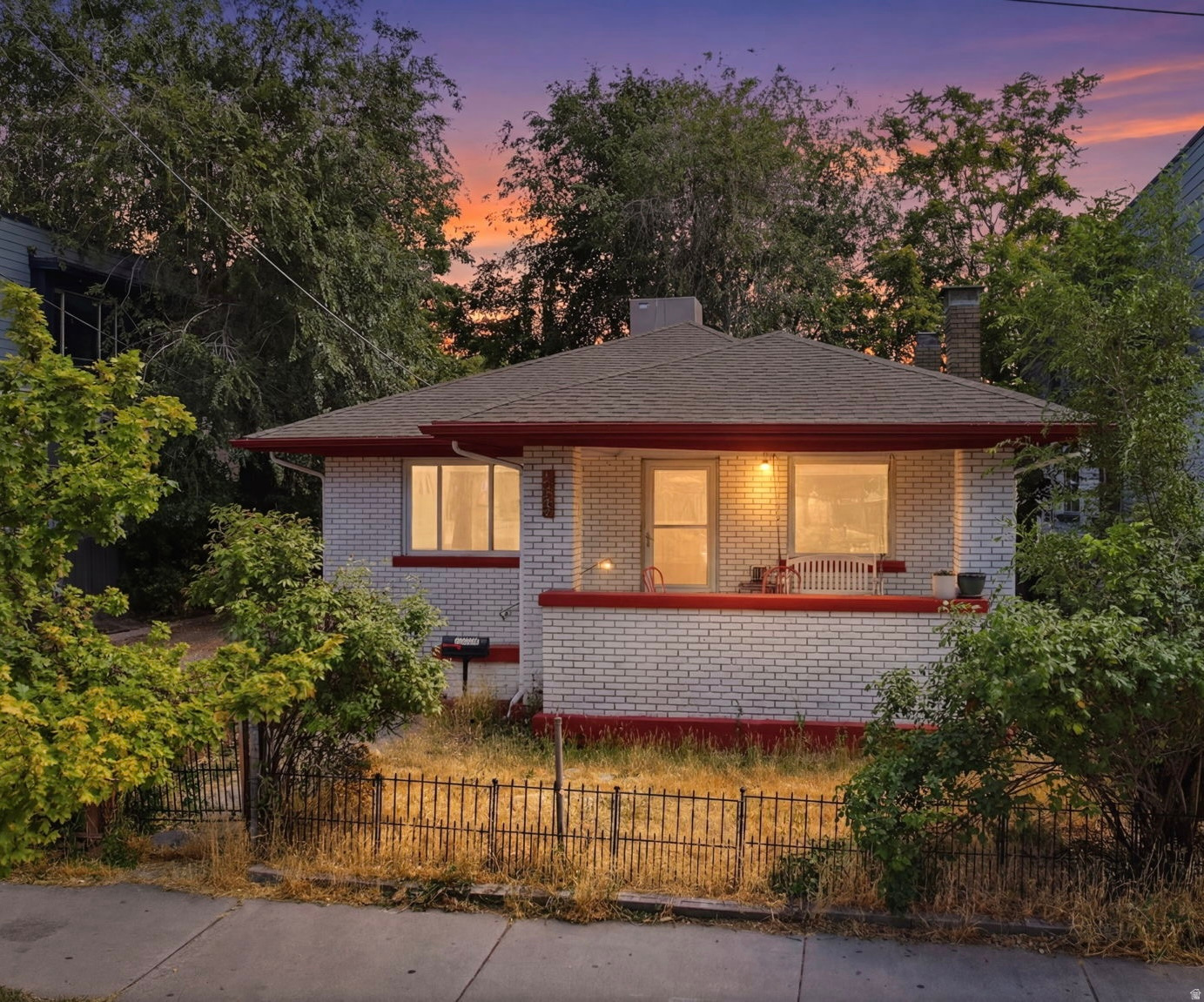 White brick facade with red trim and a covered front porch