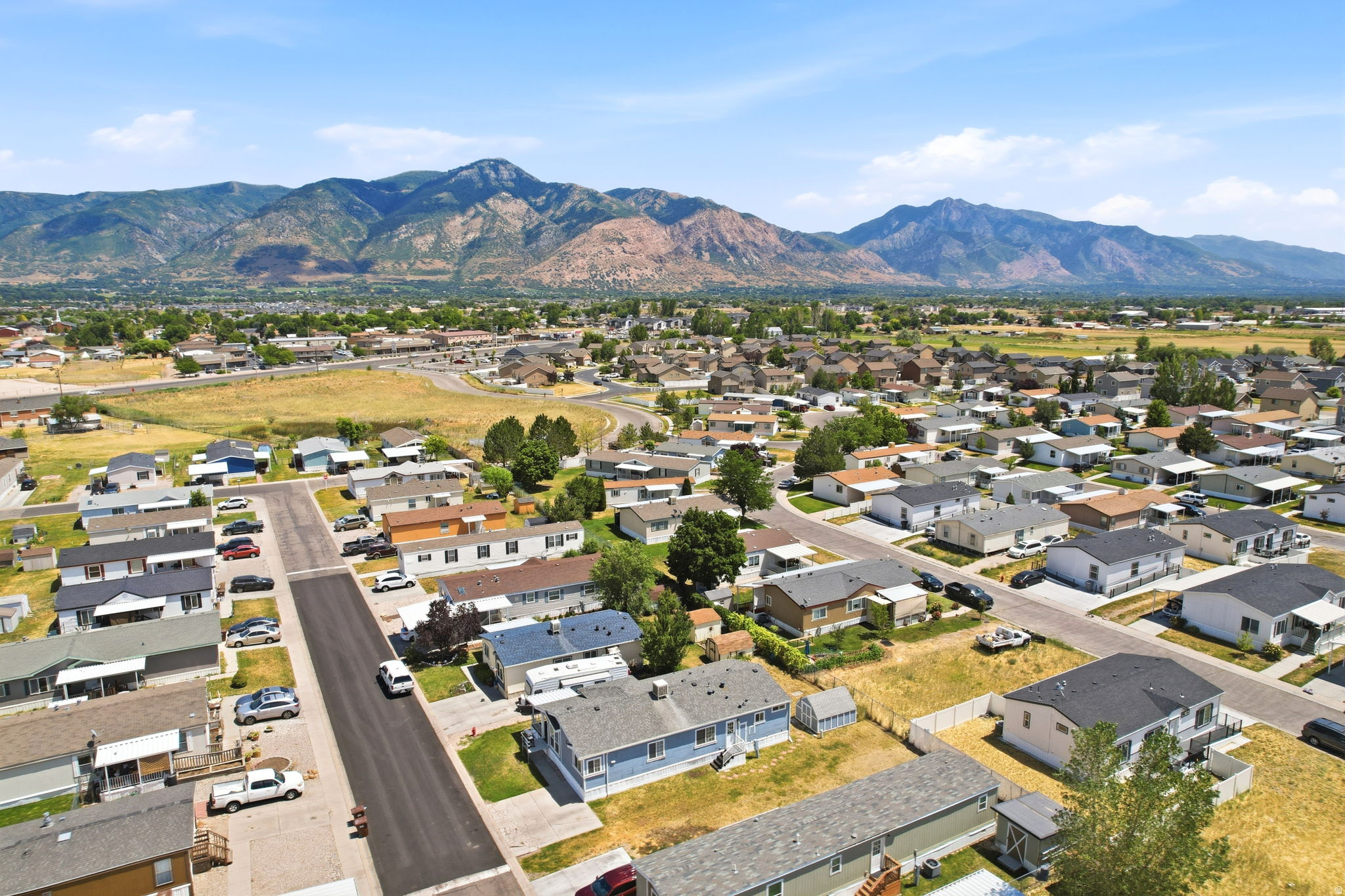 Residential neighborhood with paved streets and mature landscaping, set against a backdrop of distant mountains