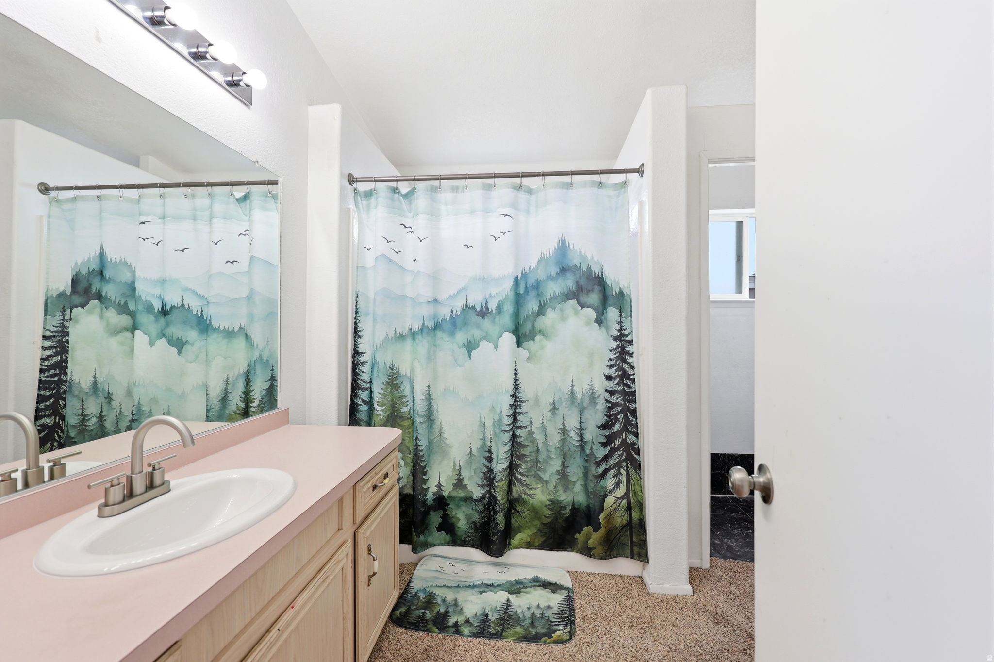 Bathroom vanity featuring a single basin sink with a brushed nickel faucet