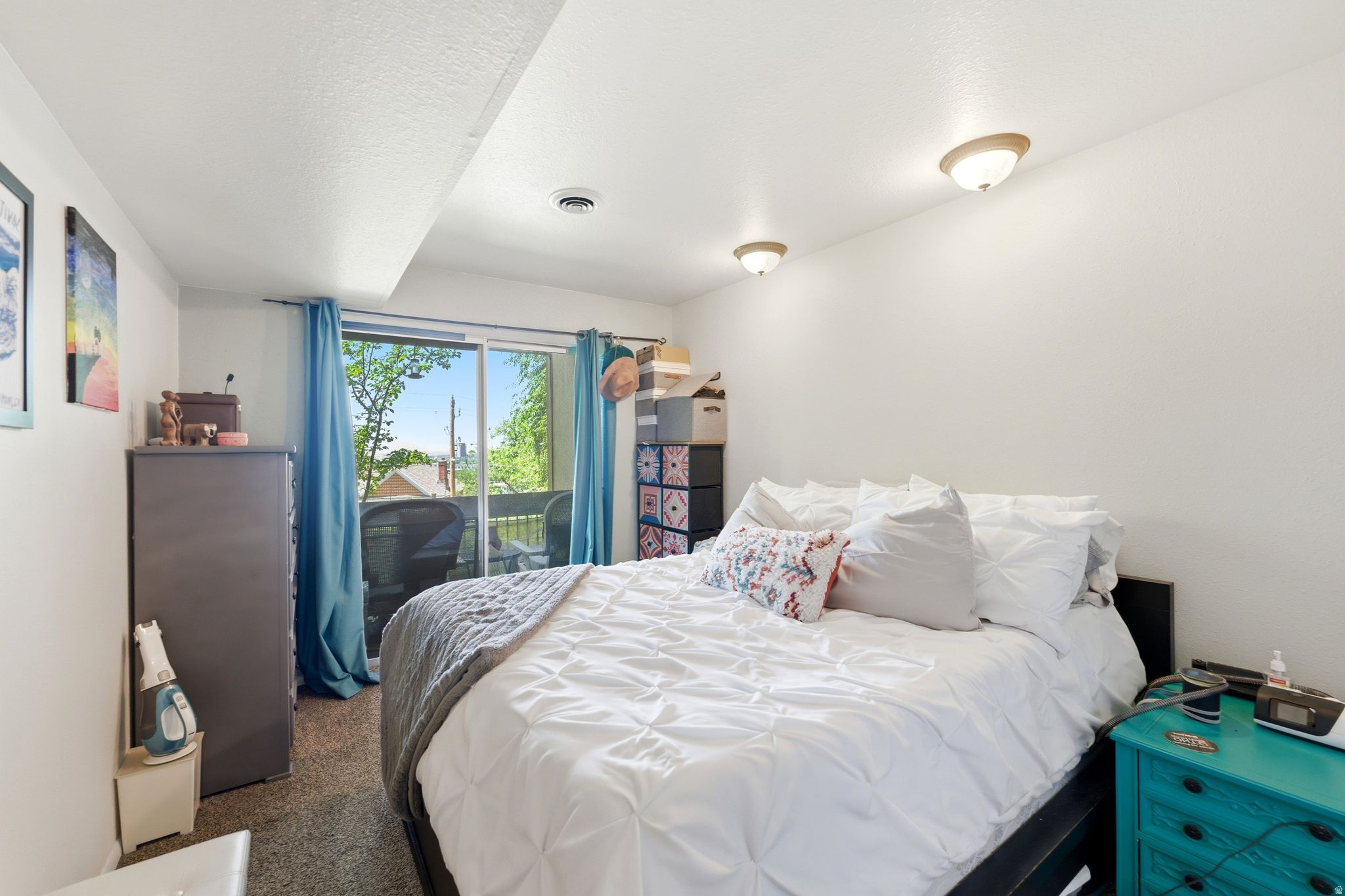 Bedroom featuring a sliding glass door to a private balcony, neutral wall paint, and overhead lighting fixtures