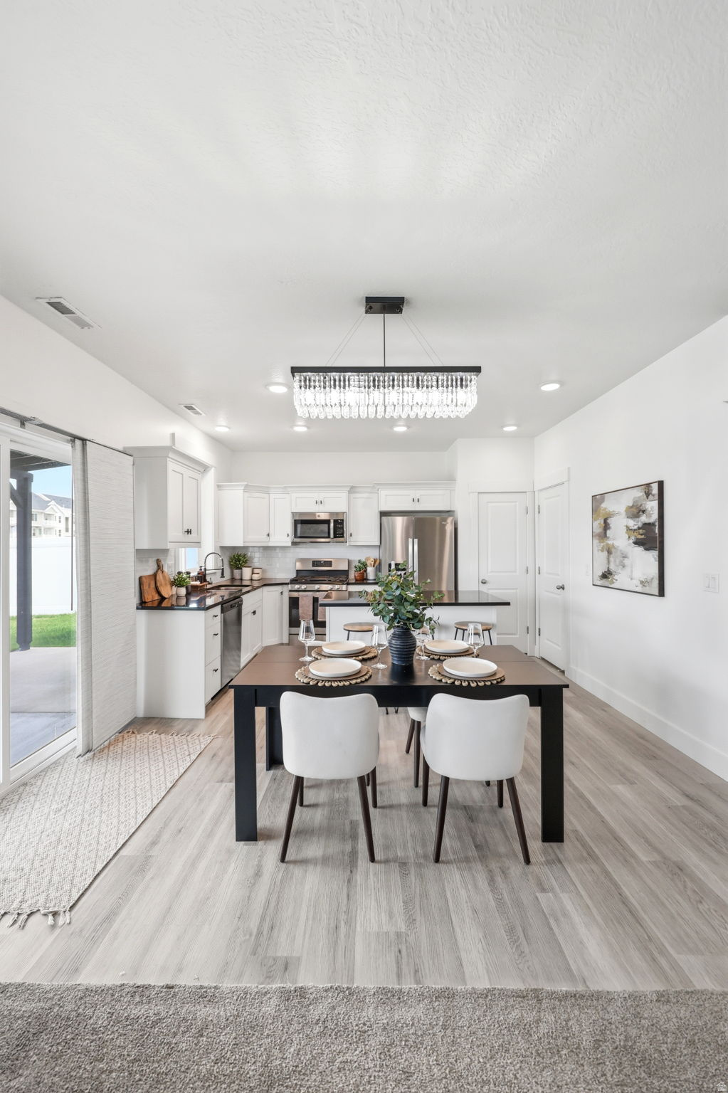 Integrated kitchen and dining area featuring wood-finish flooring