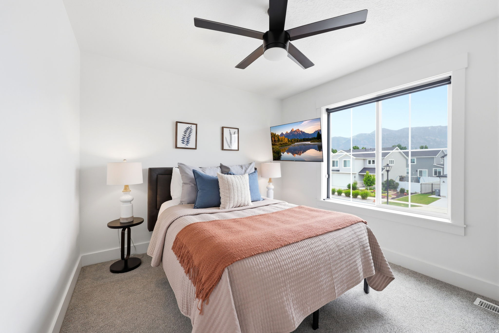 Bright bedroom with a large window and mountain scenery