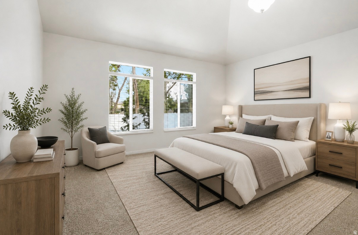 Vaulted ceiling, two large windows, neutral color palette, carpeted flooring, and a built-in light fixture