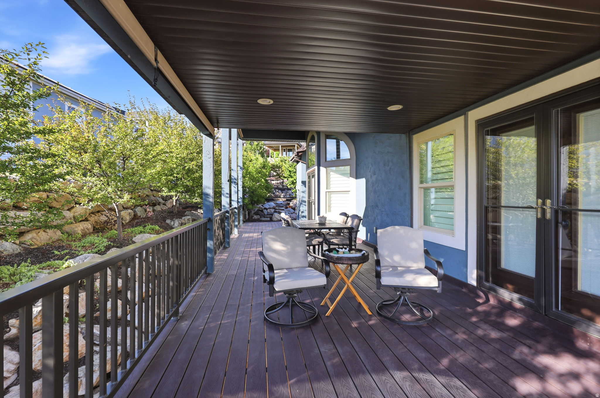 Covered outdoor patio featuring composite decking and a dark-toned ceiling