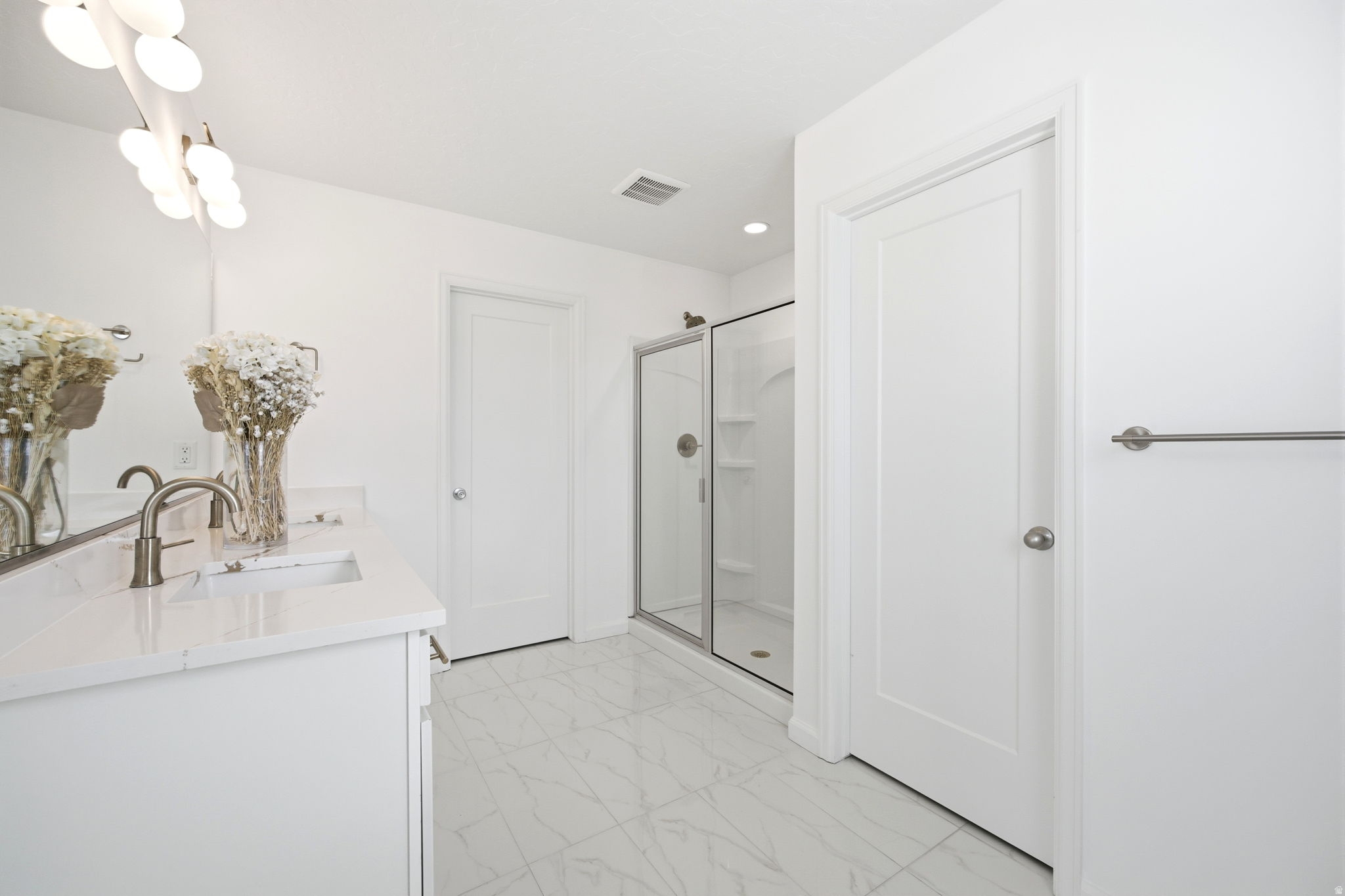 Bathroom featuring a dual vanity with quartz-finish countertops, undermount sinks, and brushed nickel faucets