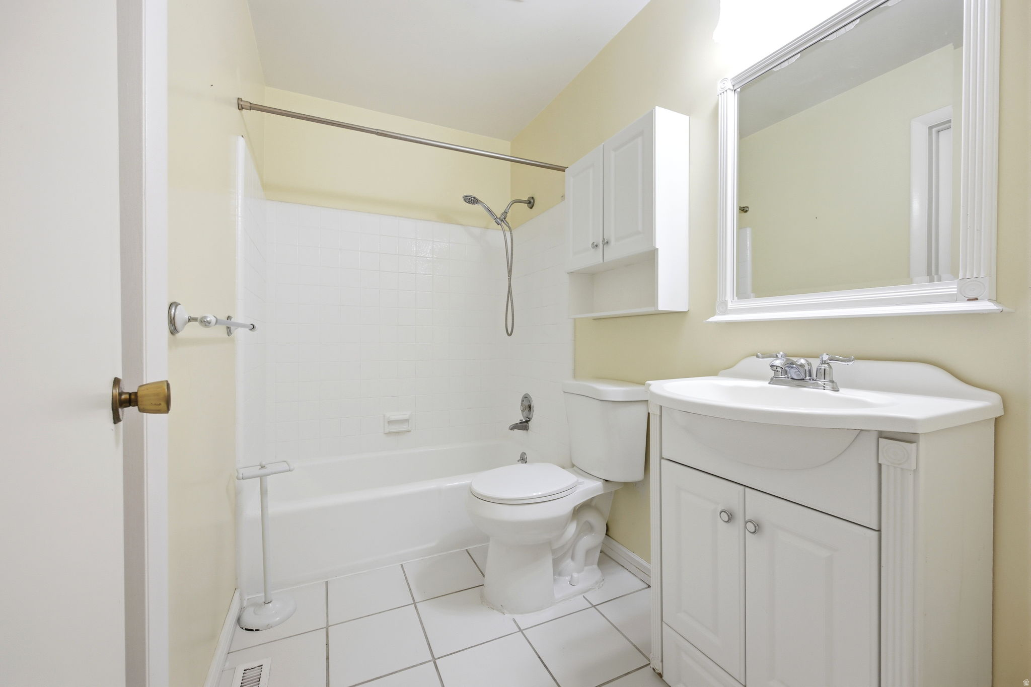 Full bathroom featuring a white vanity with integrated sink, chrome faucet, and storage cabinet- second door enters to primary bedroom.