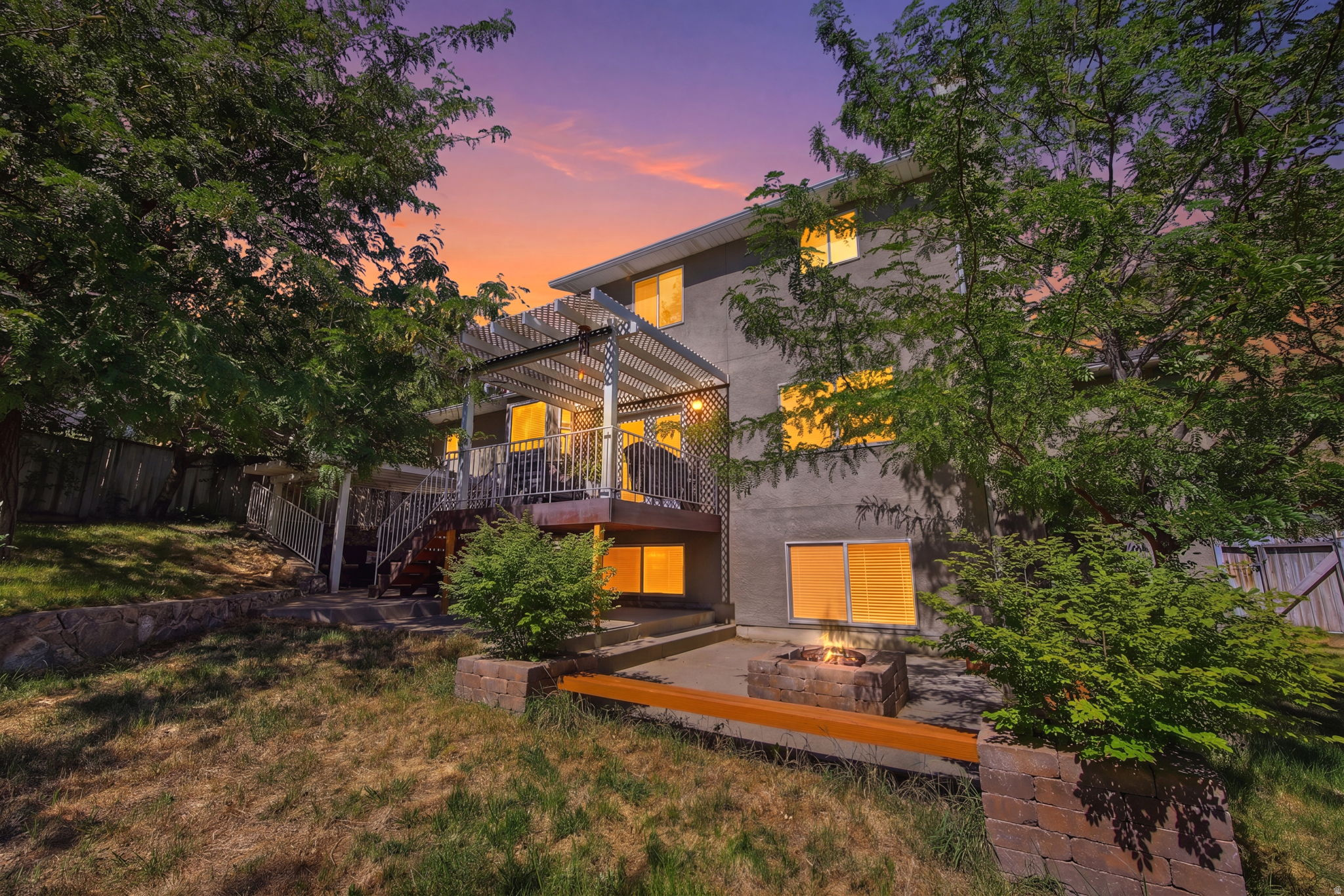 Rear exterior featuring a multi-level deck with a white pergola