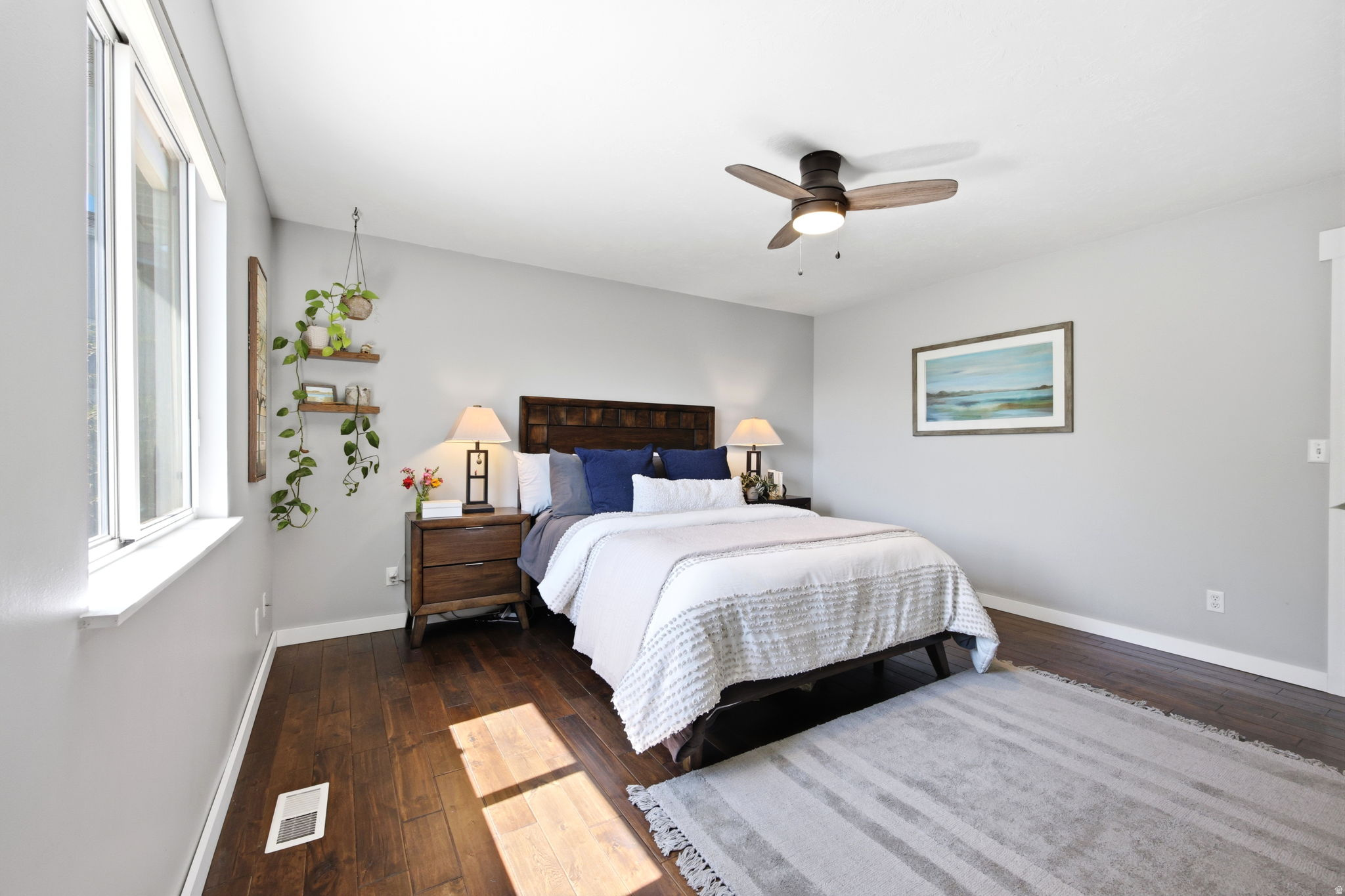 Bedroom featuring a window, wood-finish flooring, and a ceiling fan
