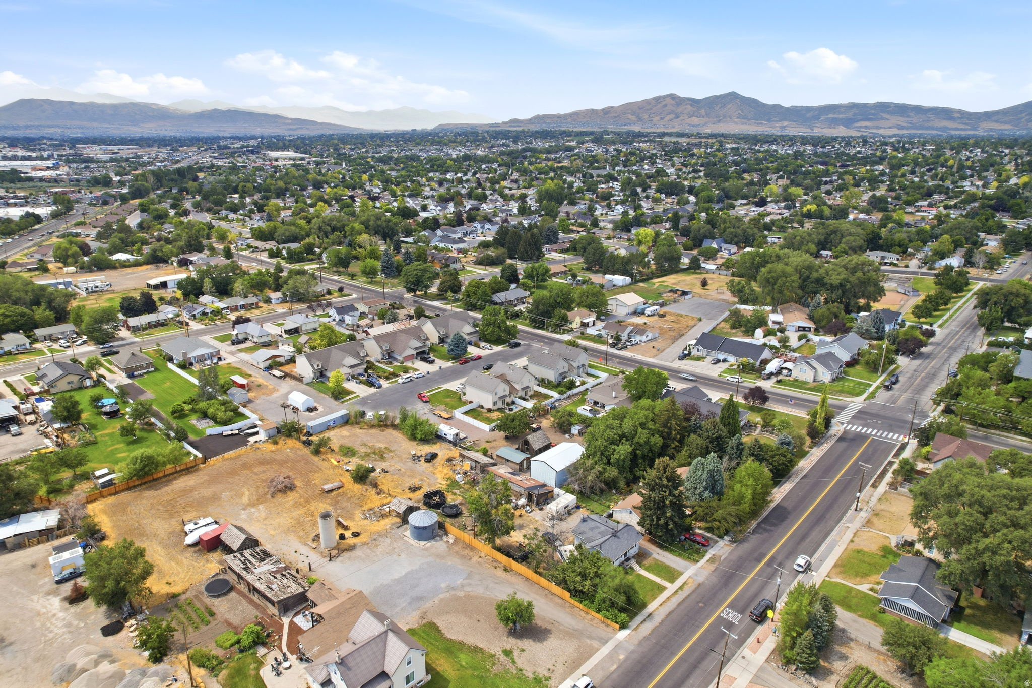 Expansive aerial view showcasing a developed residential area with numerous single-family homes, mature trees, and paved streets