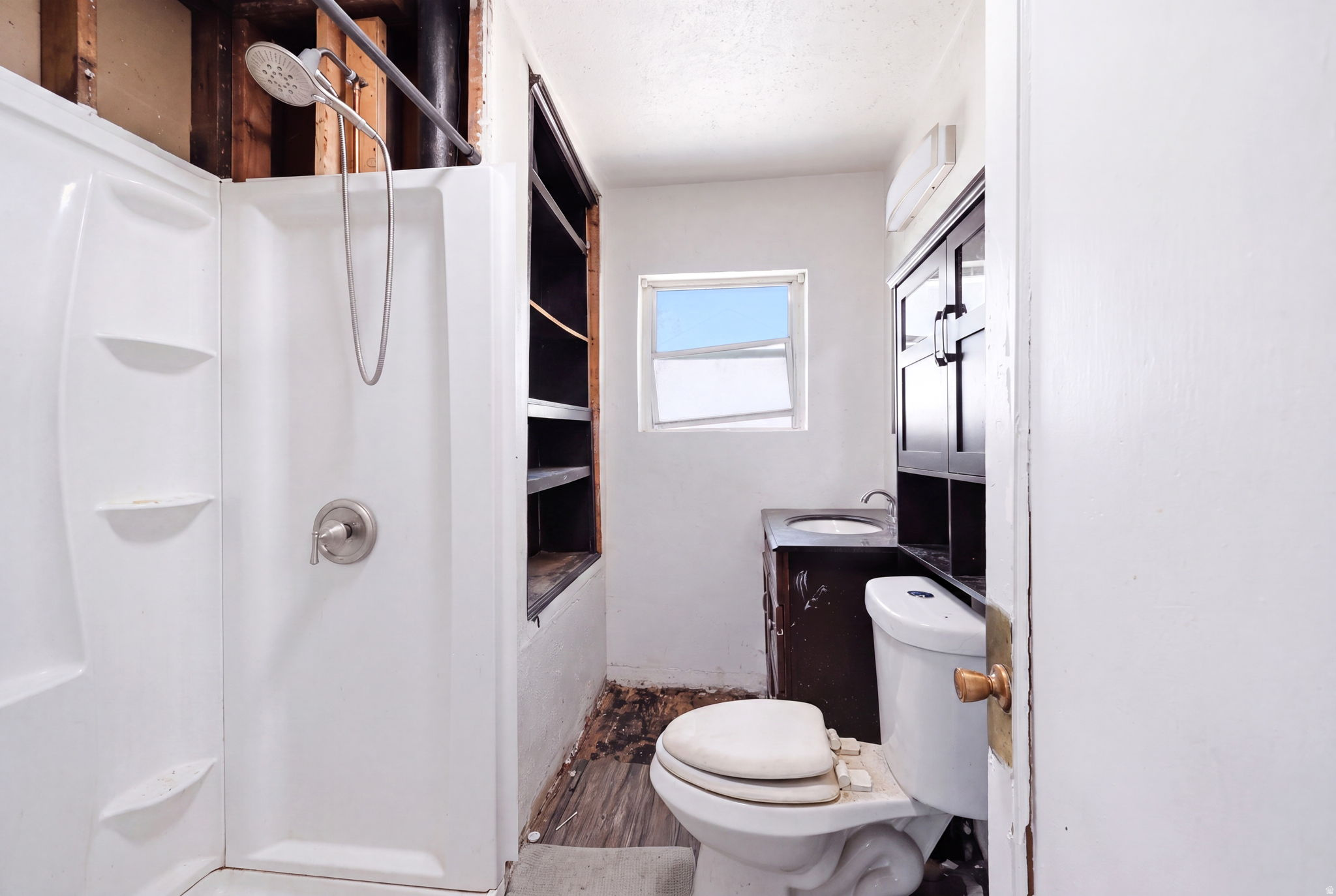 Bathroom featuring a white shower stall with a brushed nickel showerhead and faucet