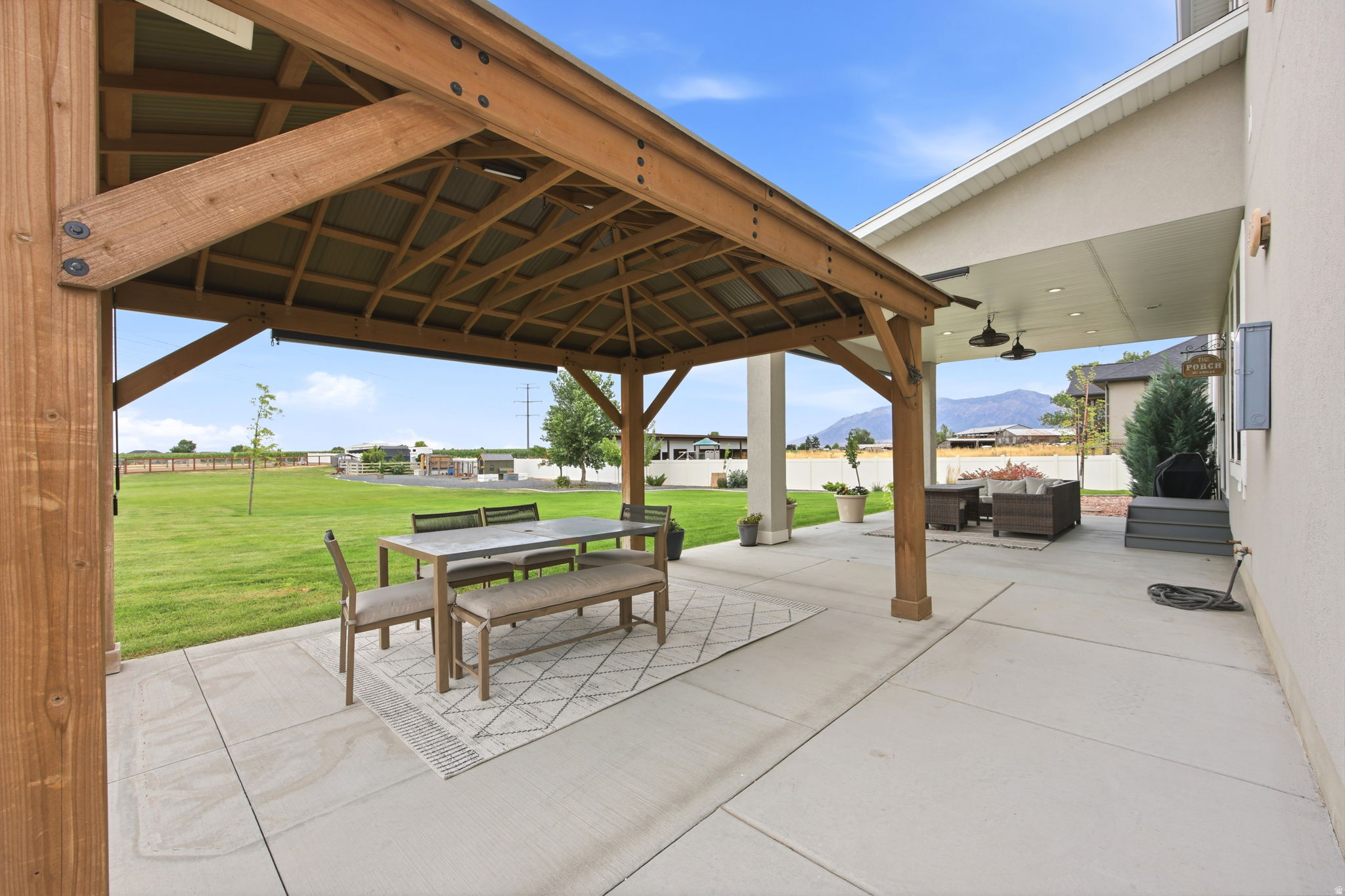 Spacious concrete patio with an attached wood pergola, offering ample outdoor living space