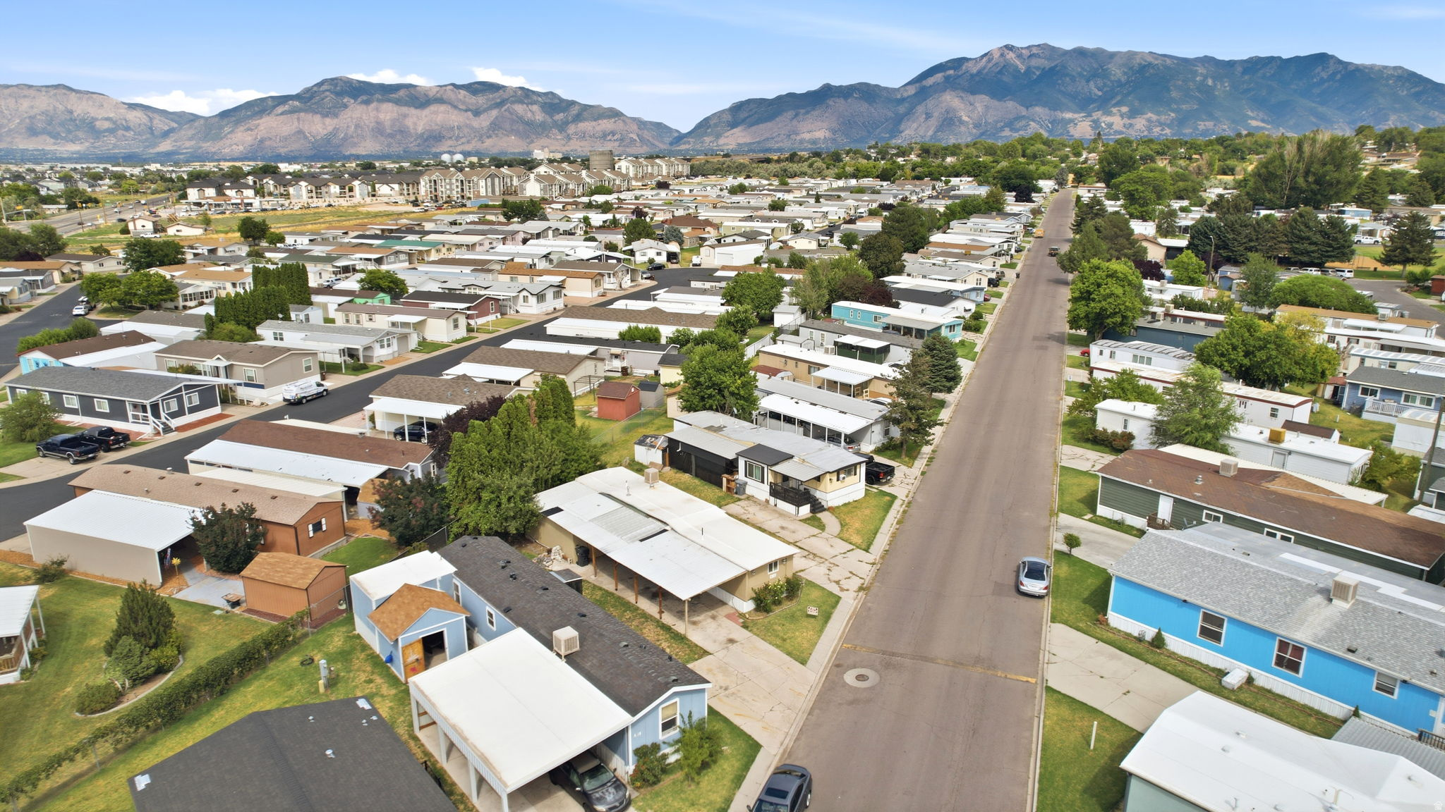 Aerial perspective of a neighborhood with paved roads and a mix of single-story residences