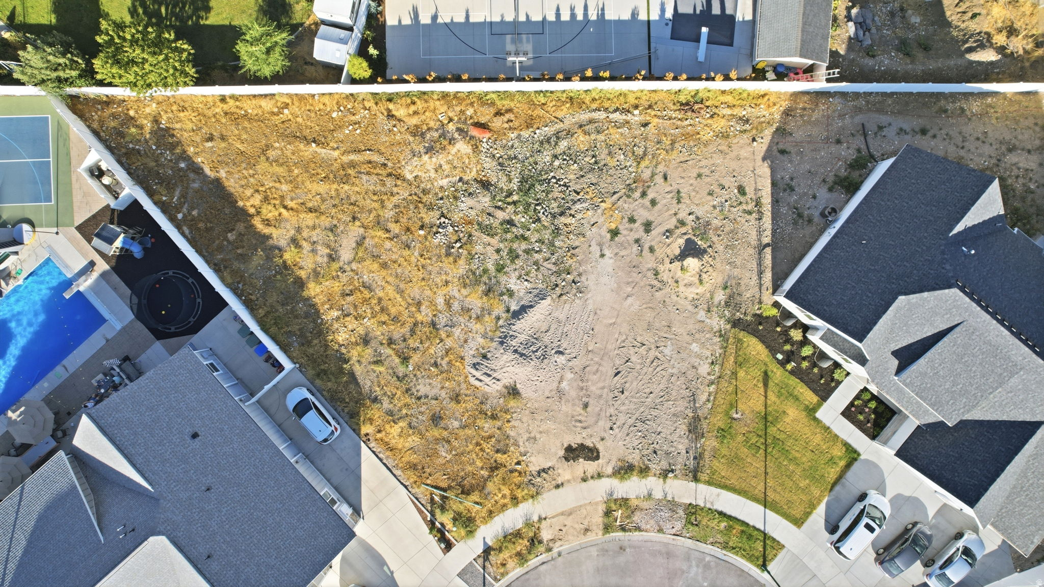 Spacious undeveloped lot featuring a natural terrain, street access, and proximity to established properties