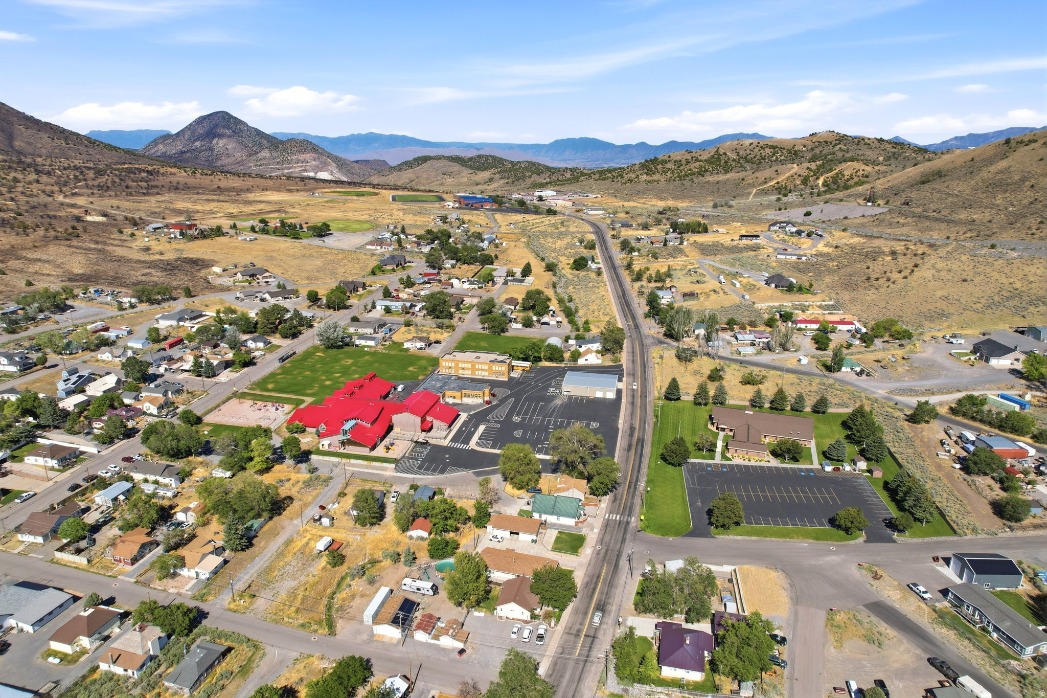 Expansive aerial perspective showcasing a residential community nestled within a mountainous landscape