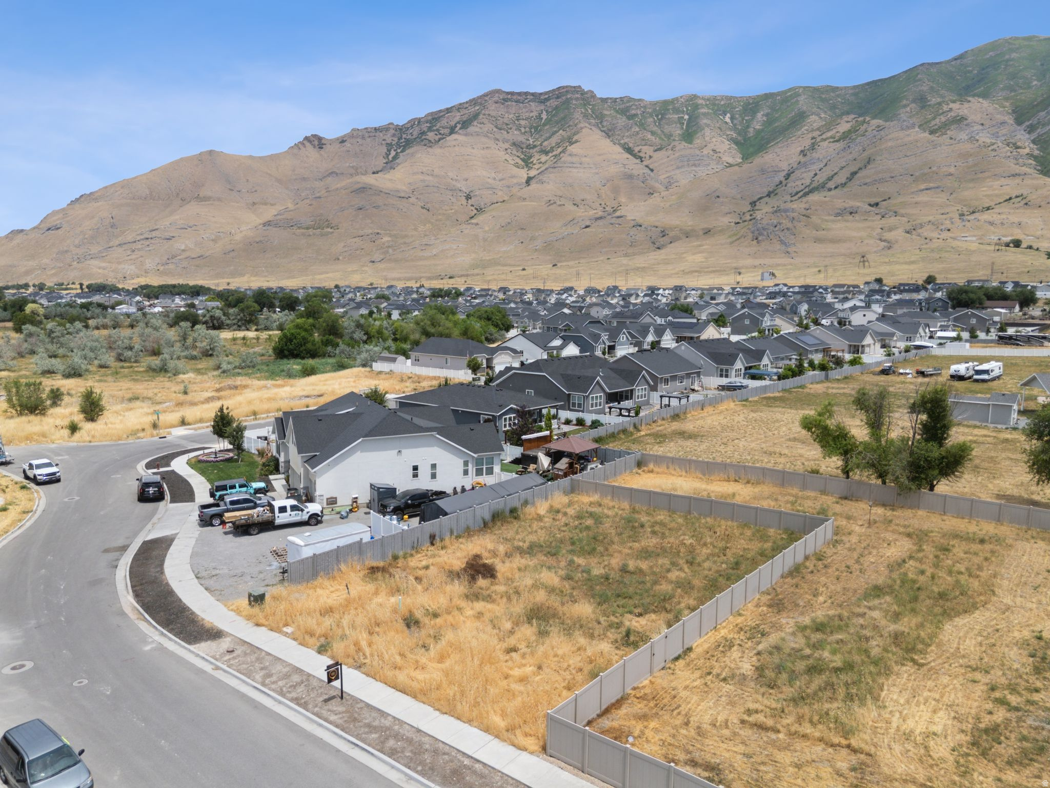 Expansive undeveloped lots featuring perimeter fencing, level topography, and mountain scenery