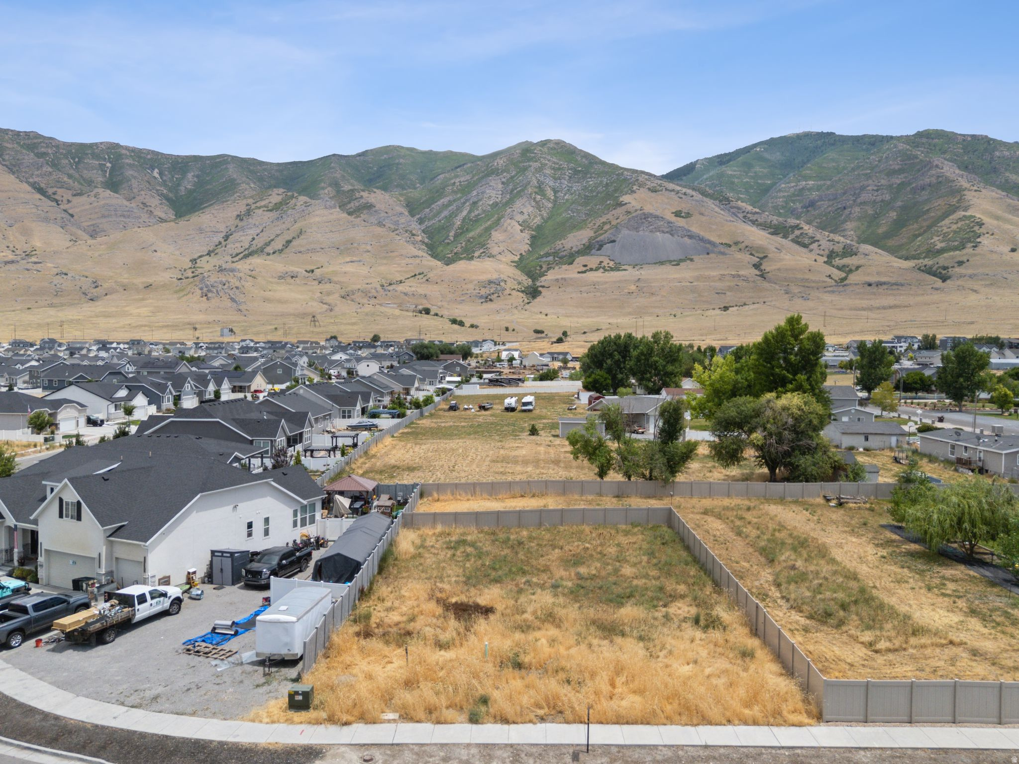 Expansive land parcel featuring a perimeter fence and mountain backdrop