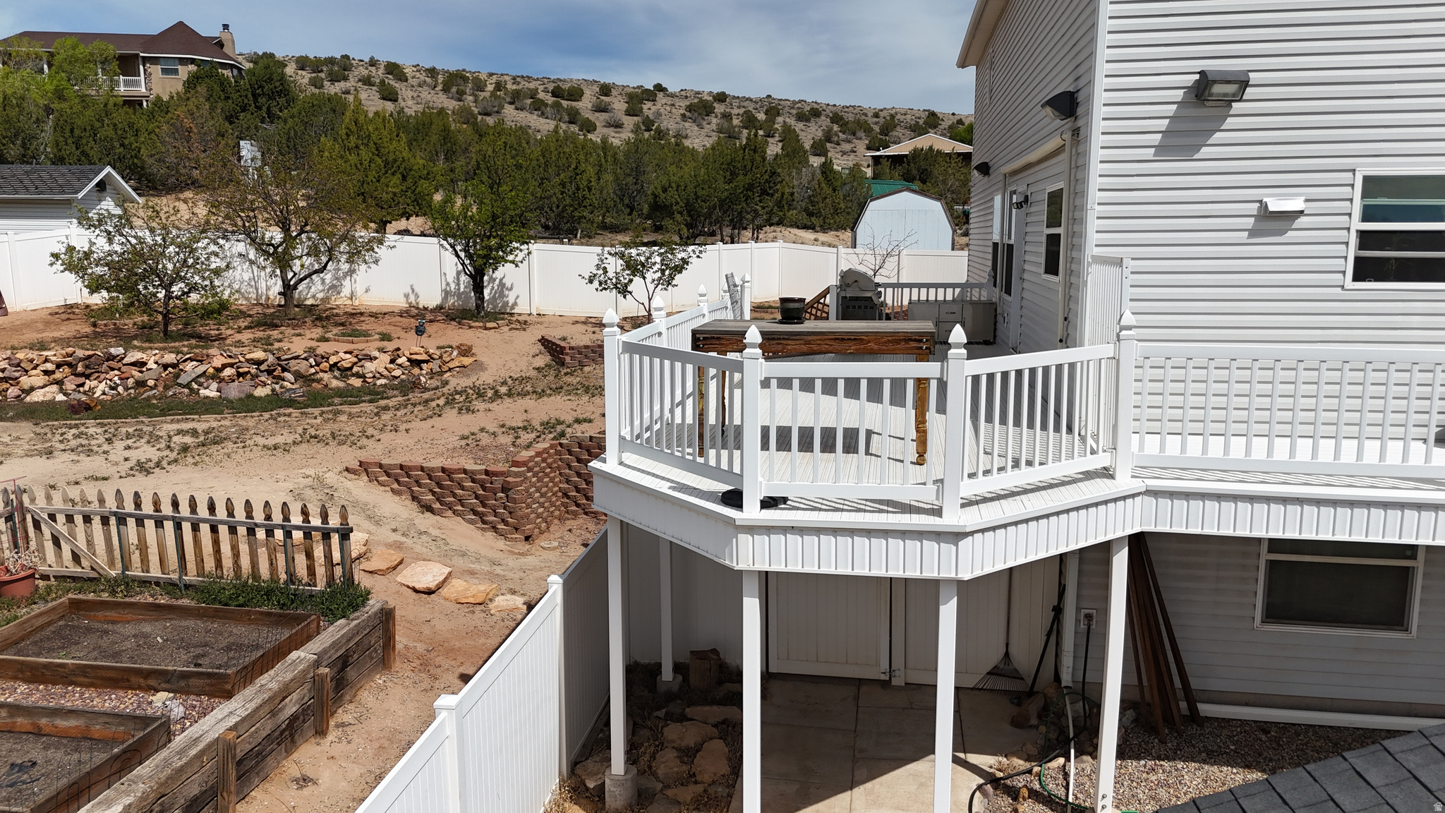 White vinyl siding exterior with an elevated deck featuring white railings