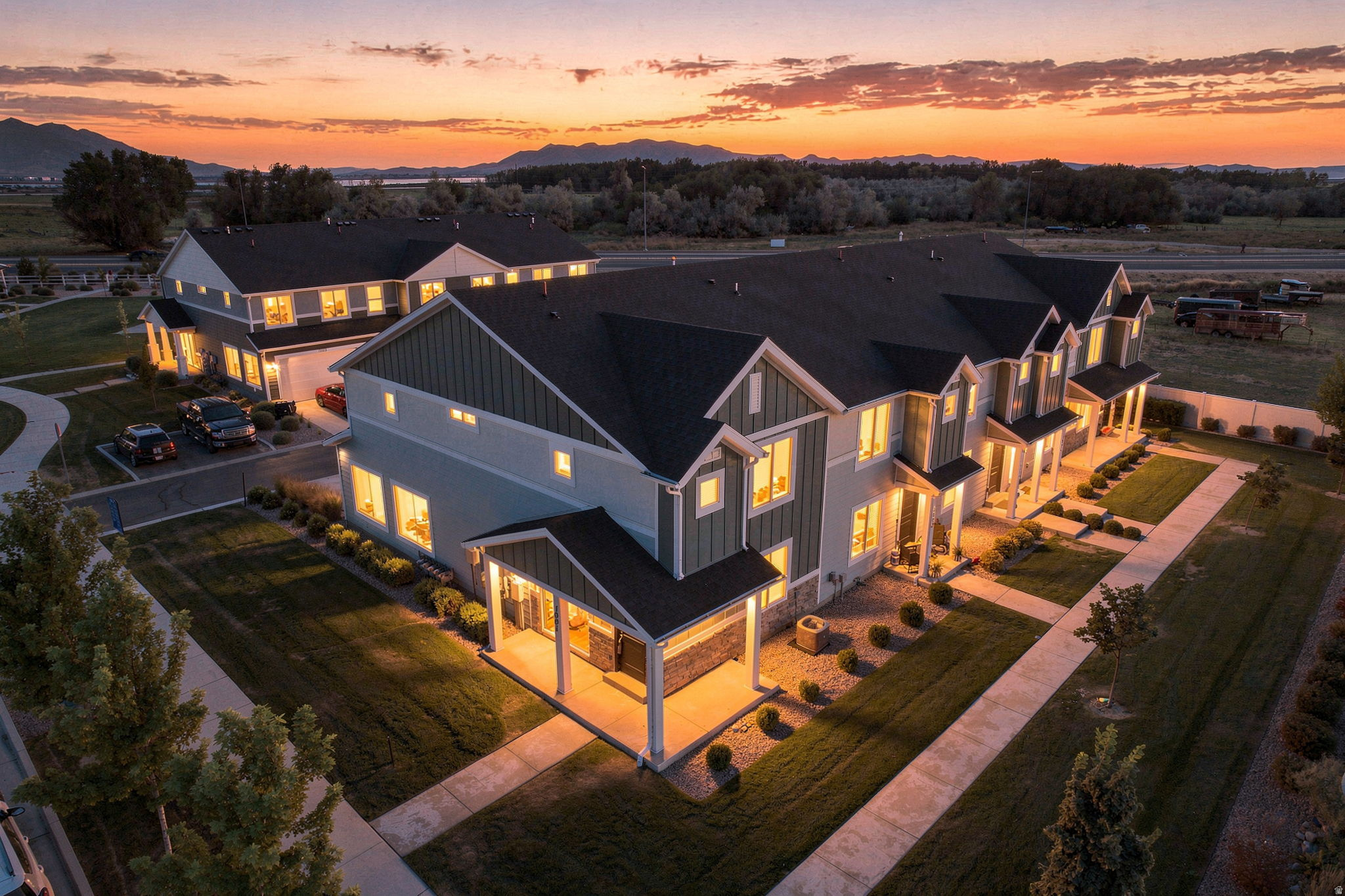 Contemporary townhome architecture with covered front porches, extensive hardscaping, and landscaped grounds