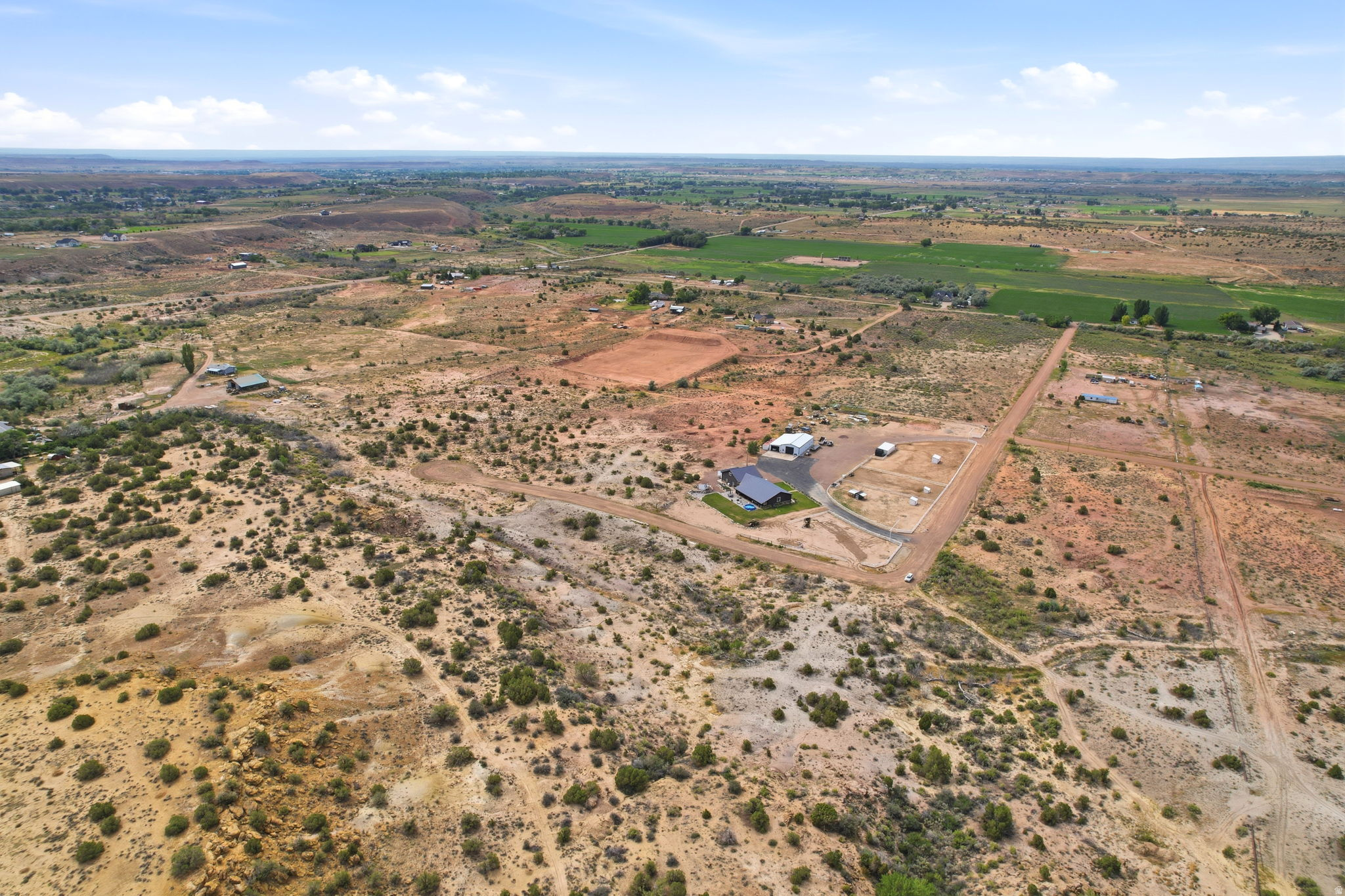 Expansive property featuring a contemporary residence, detached garage, and substantial undeveloped land