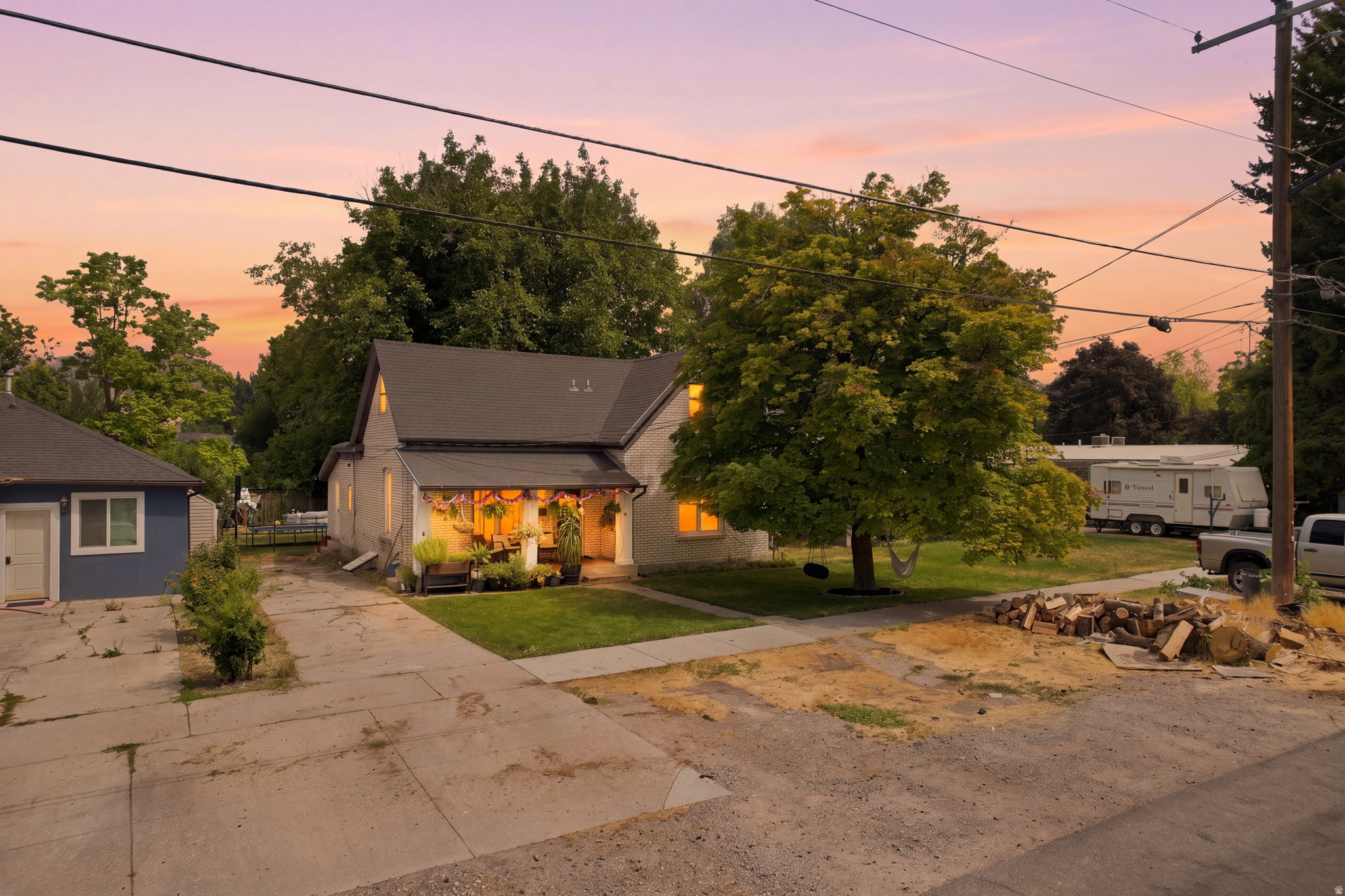 Durable roof shingles, covered front porch, detached outbuilding, mature landscaping, and concrete driveway