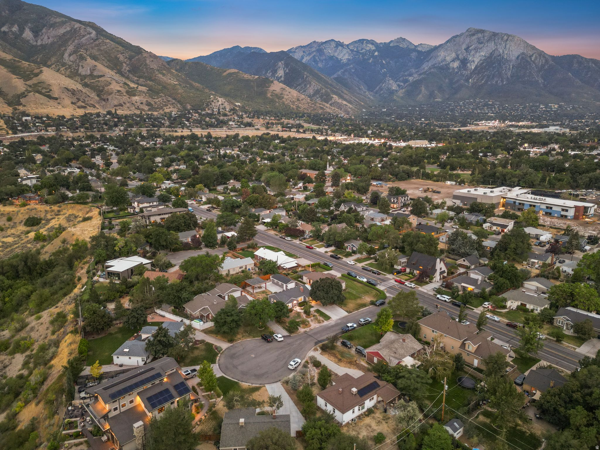 Aerial view of established residential neighborhood nestled in a valley setting, surrounded by mature landscaping and tree-lined streets