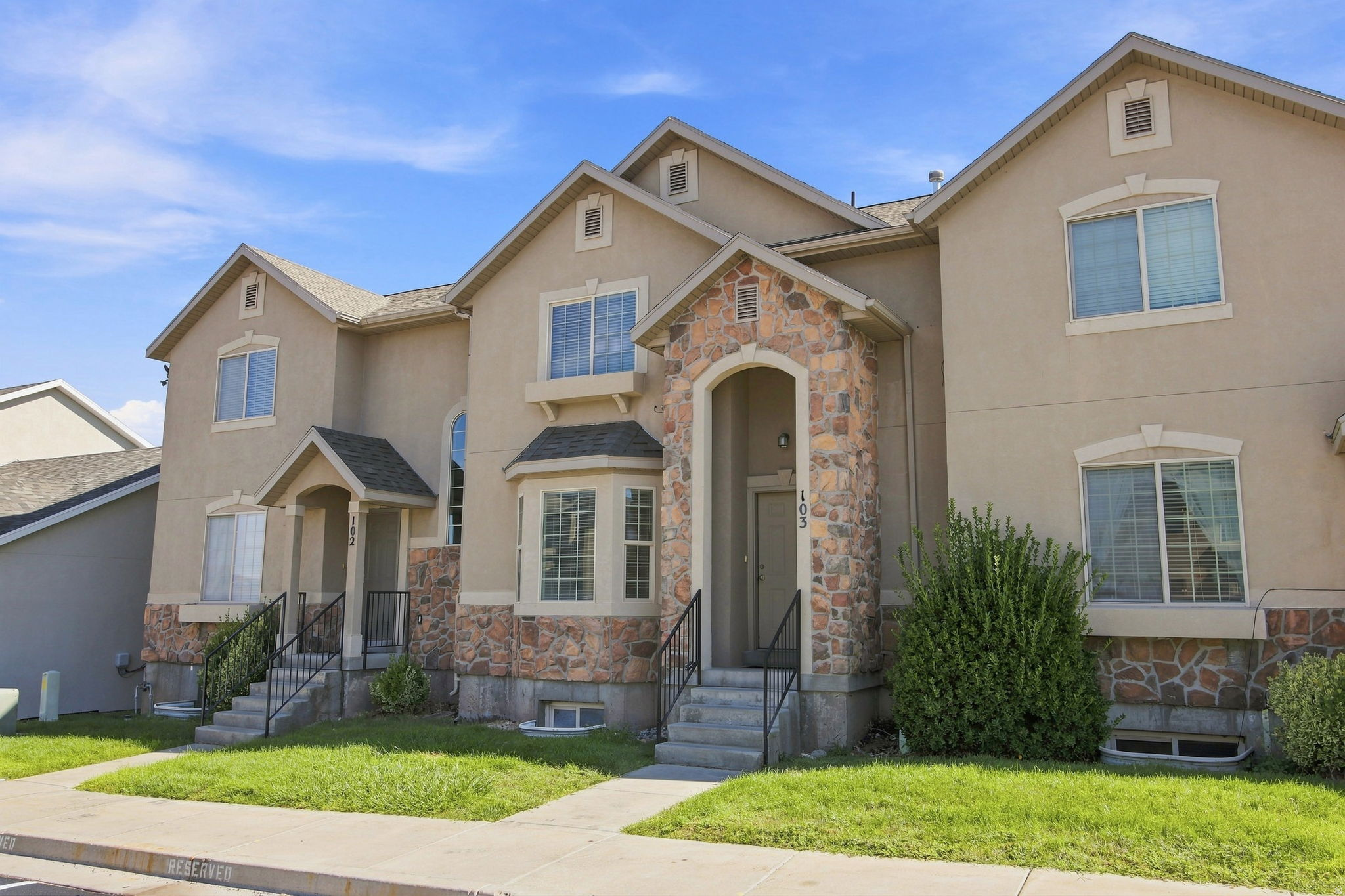 Multi-level exterior featuring stone accents, arched entry, and bay window