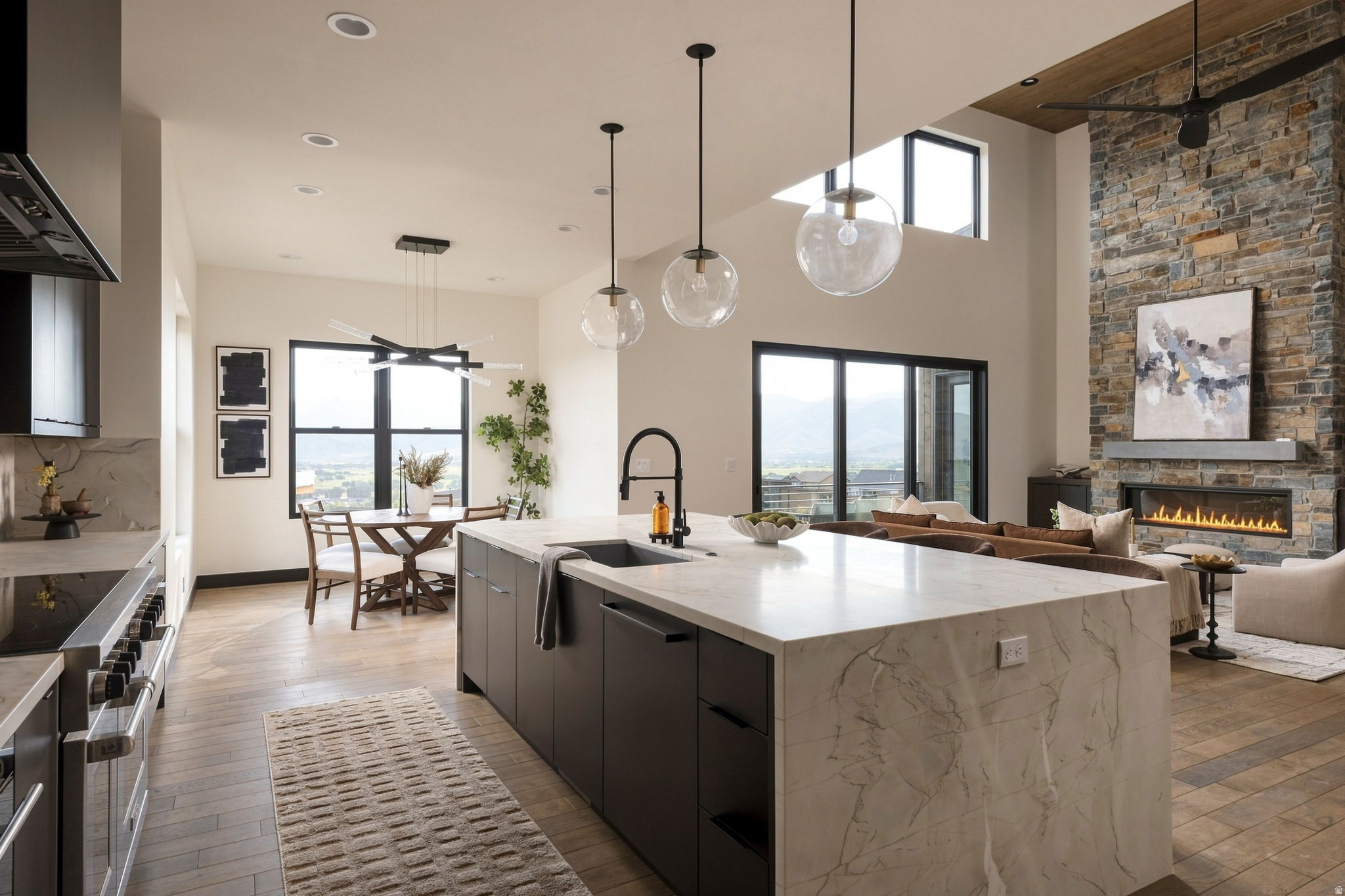 Open-concept living space featuring a stone accent wall, linear fireplace, and ceiling fan