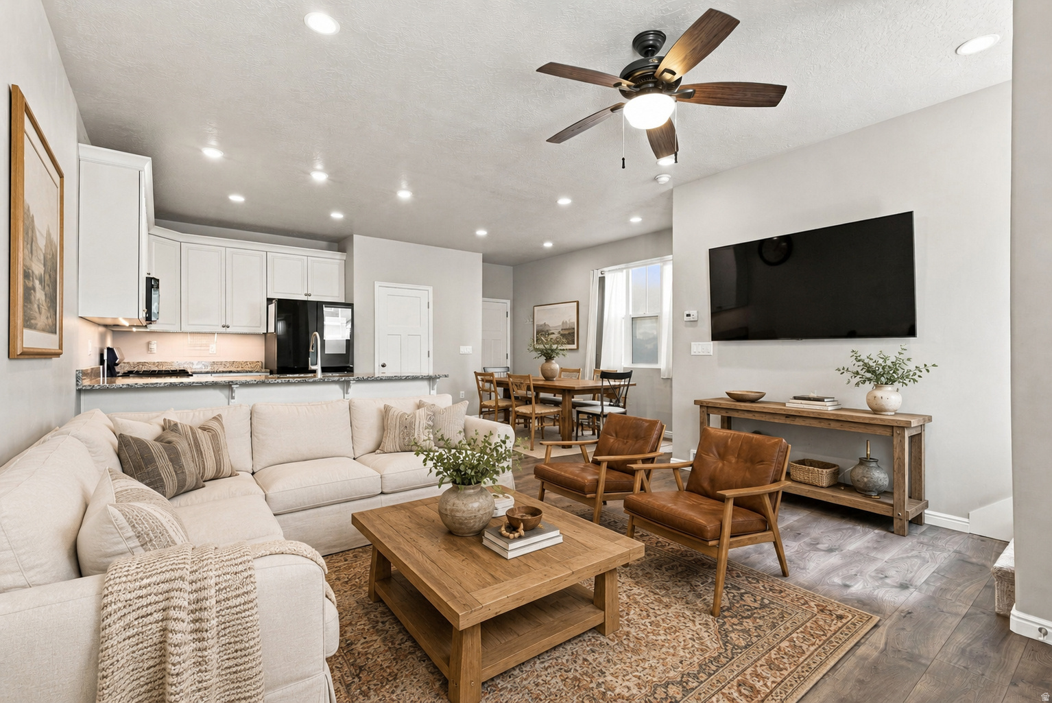 Open-concept living area featuring wood-finish flooring, recessed lighting, and a ceiling fan