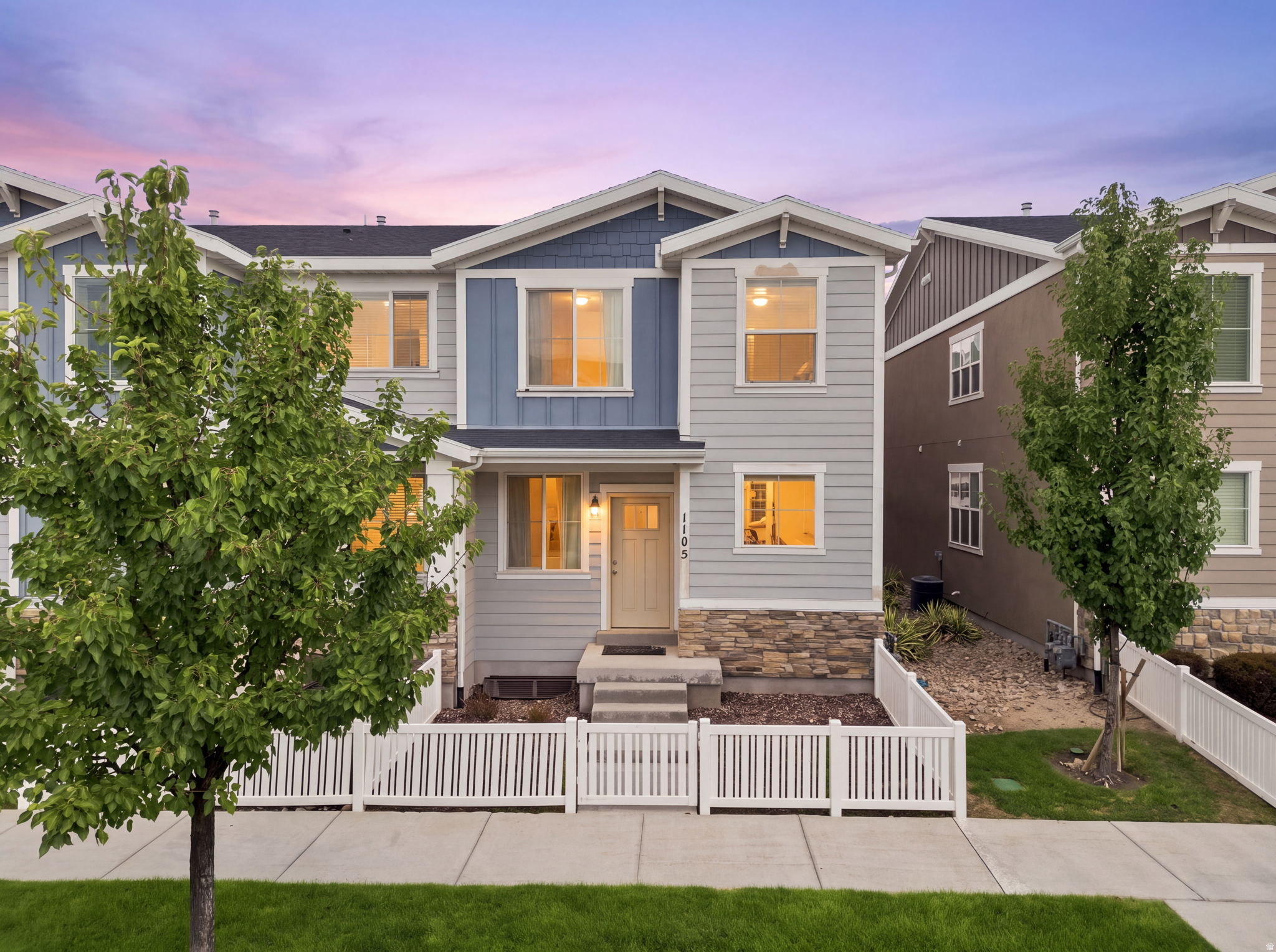 Two-story residential architecture with light gray siding and blue accent panels