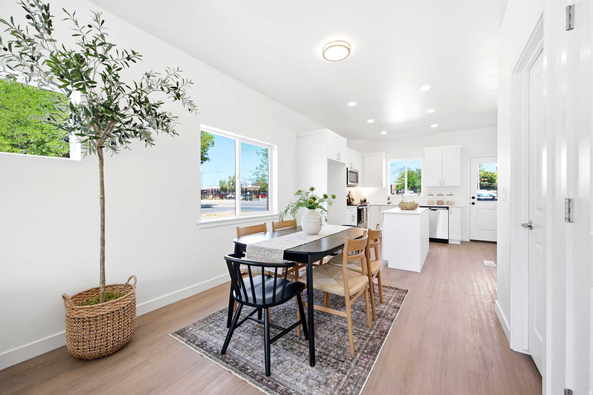 Open-concept living space featuring wood-finish flooring, white walls, and recessed lighting