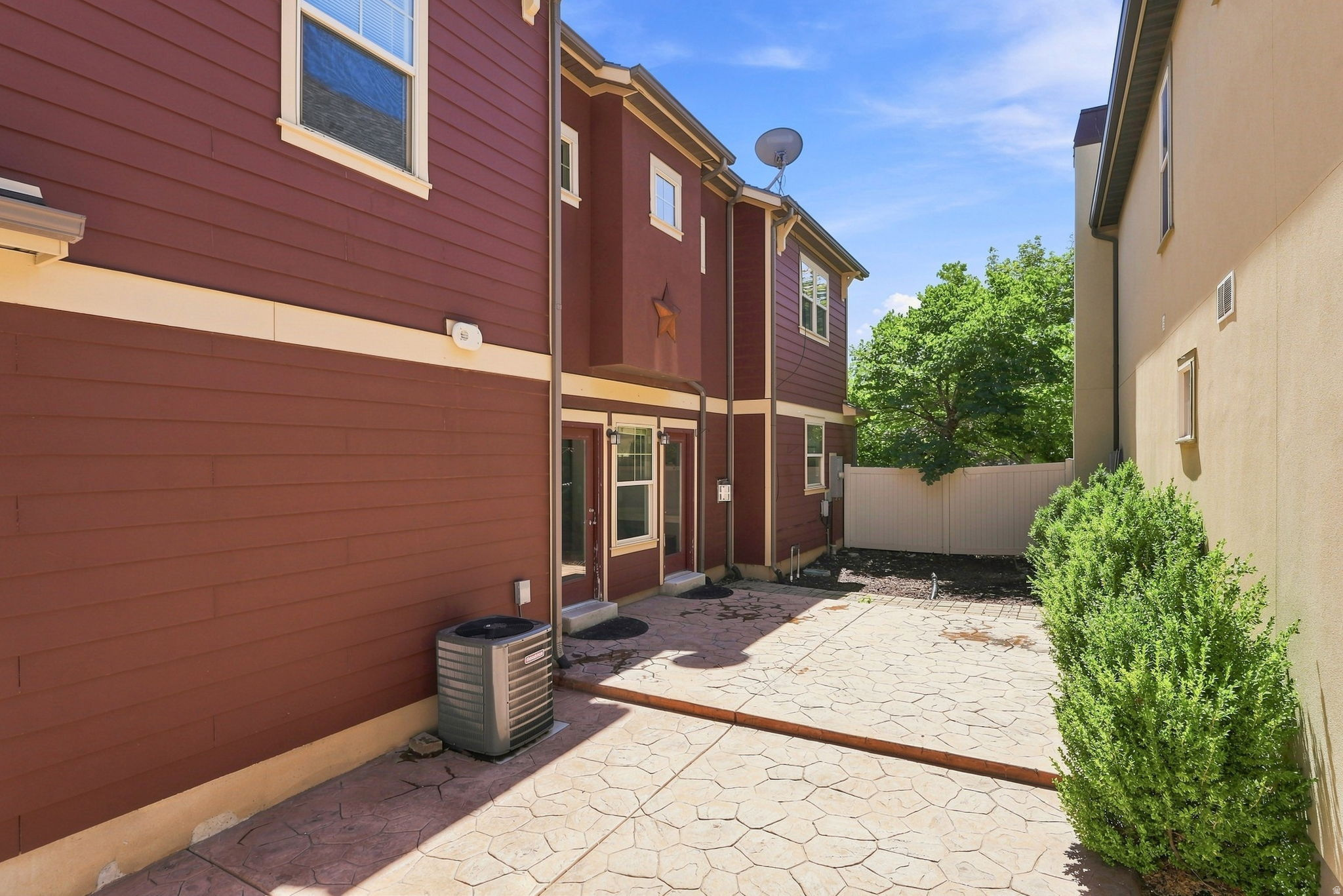 Stamped concrete patio with brown siding and beige trim