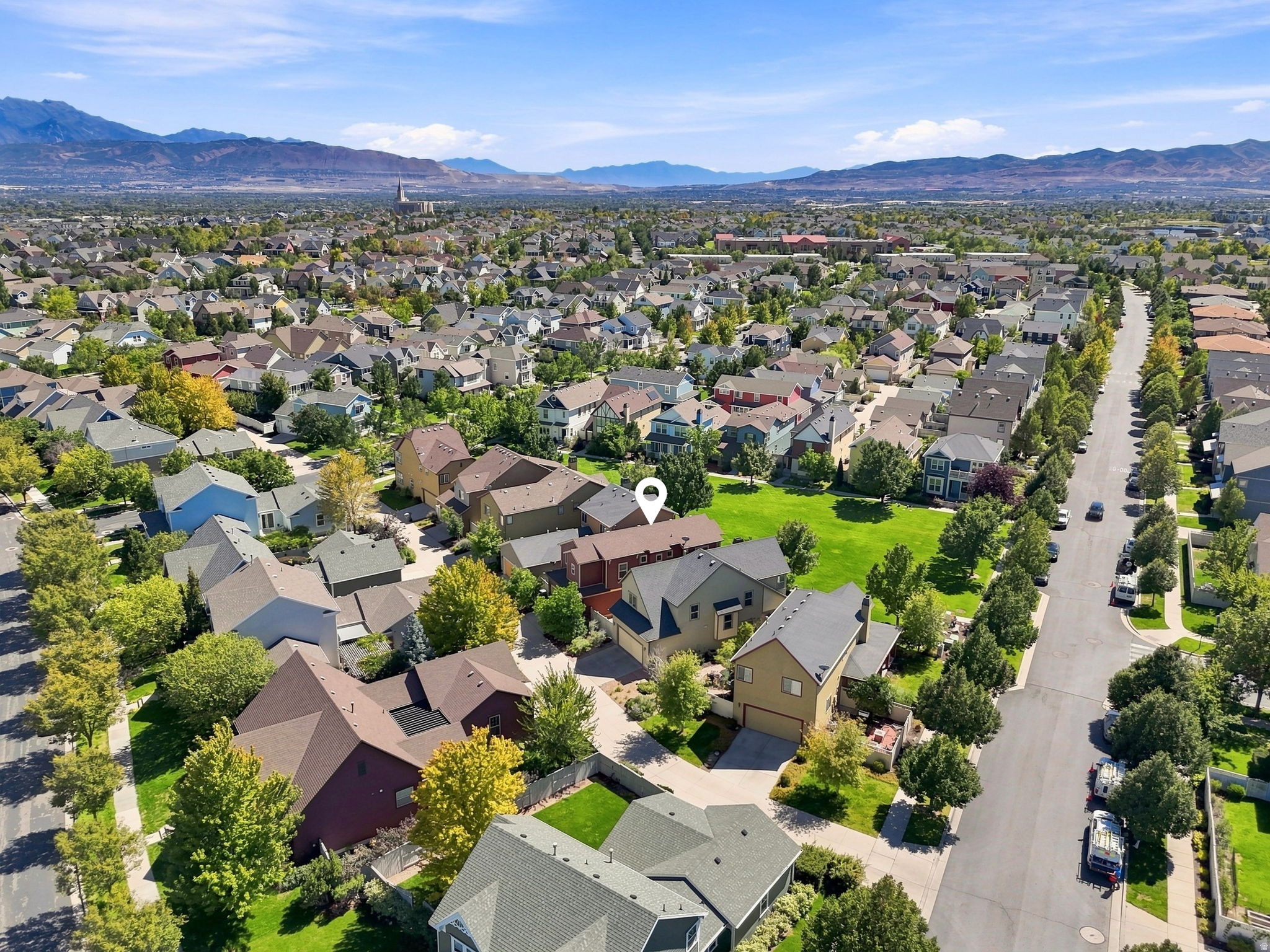 Aerial perspective of a residential community featuring mature trees and mountain scenery