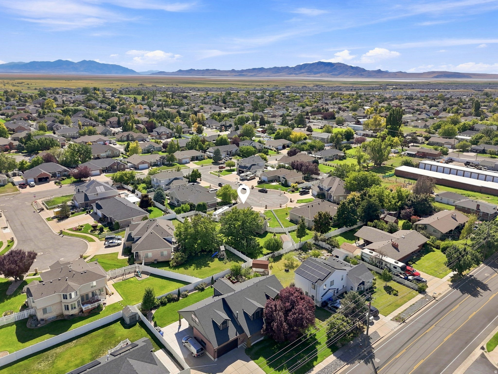 Expansive residential area featuring established homes, mature trees, and mountainous terrain in the distance