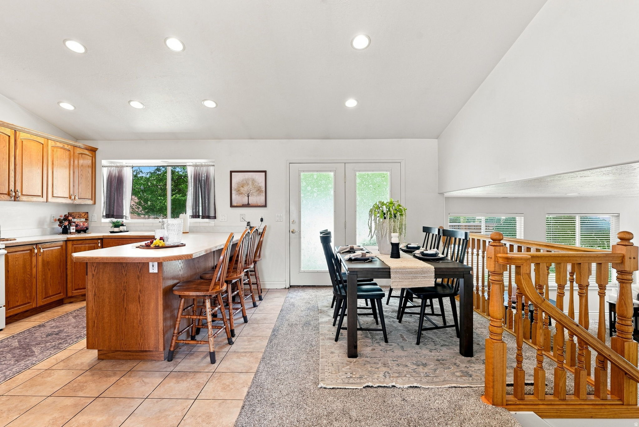 Kitchen with wood cabinetry, tile flooring, and an eat-at island with seating
