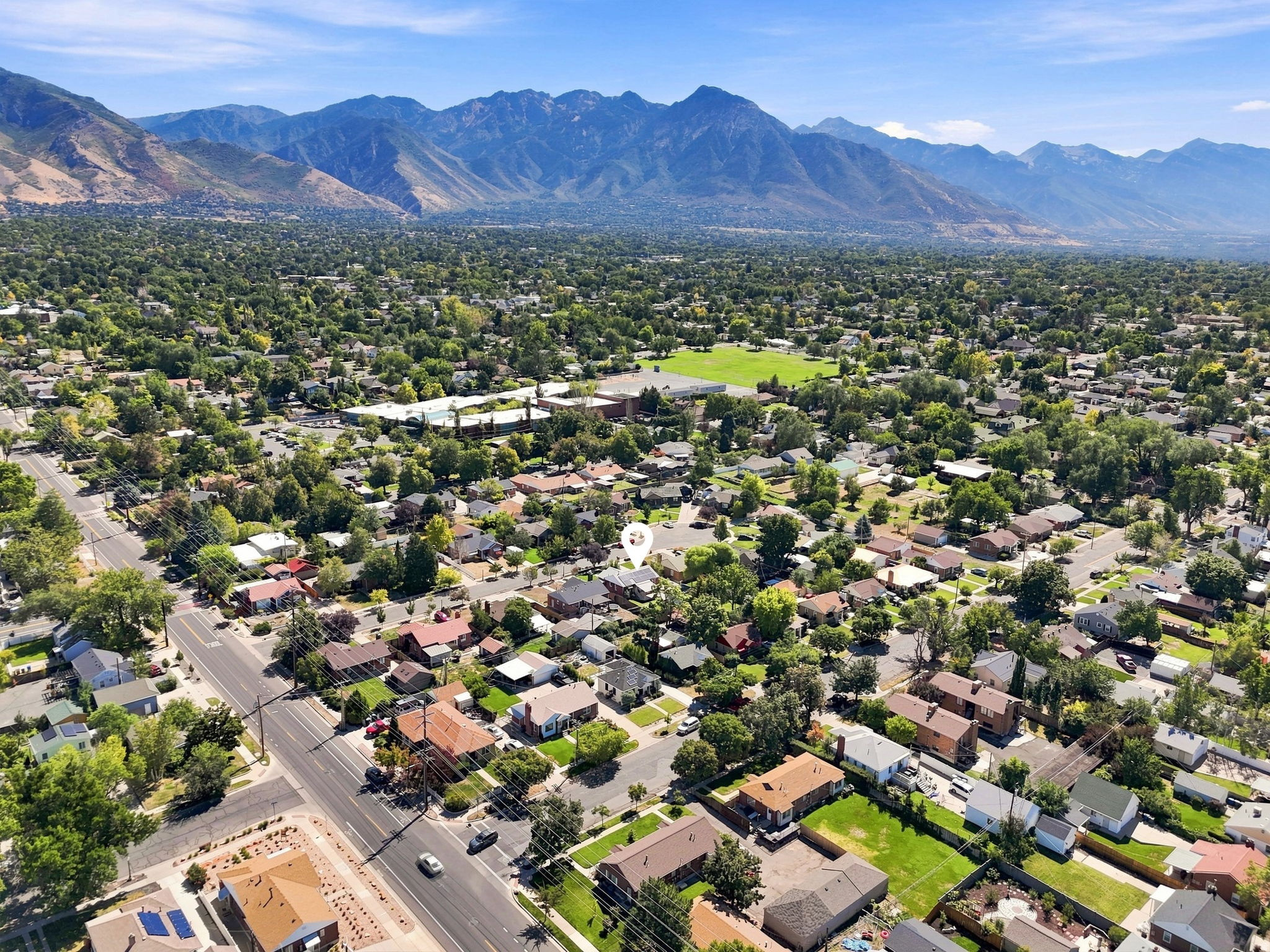 Expansive neighborhood with mature trees and mountain backdrop