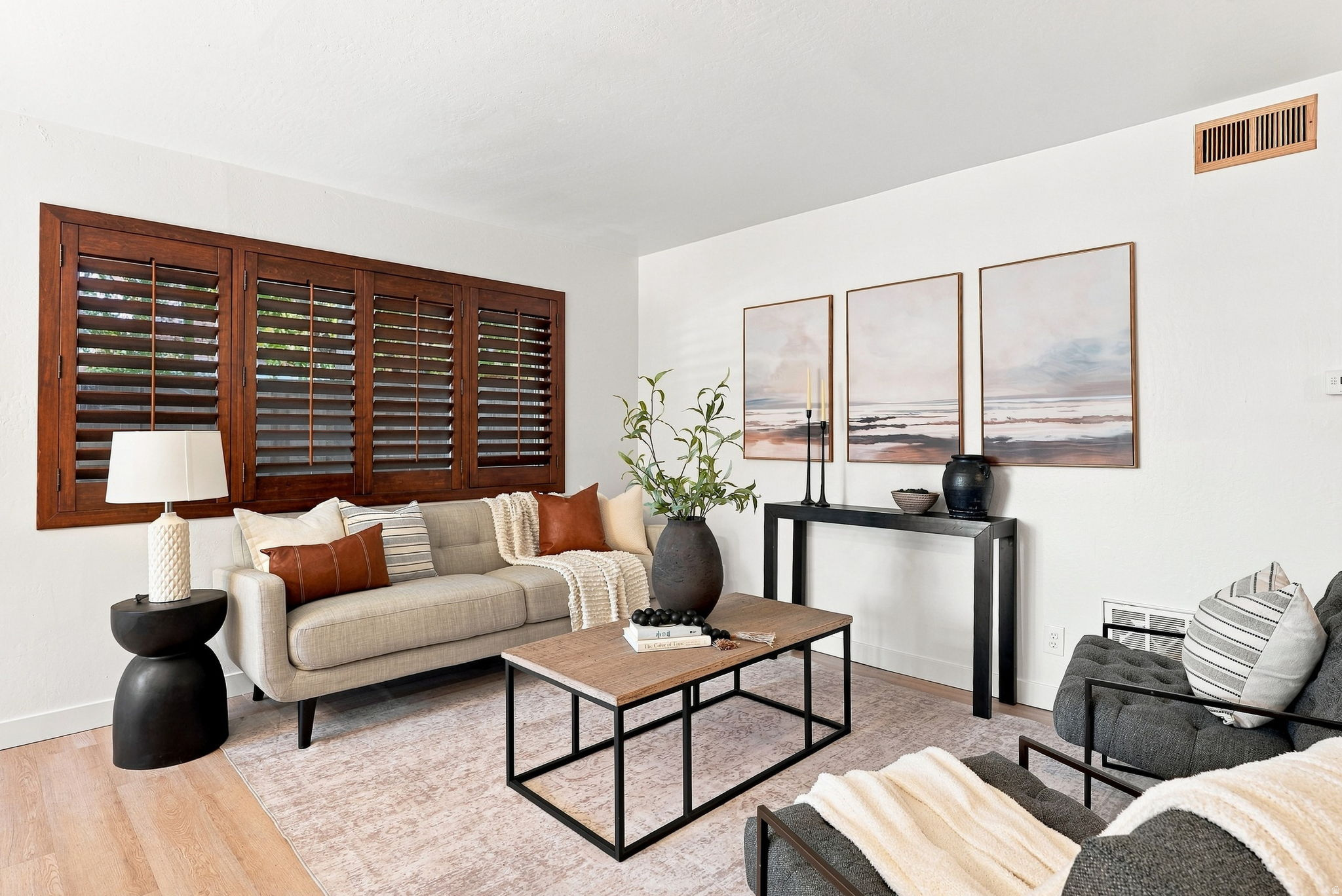 Wood-finish flooring, white walls, and dark wood window shutters