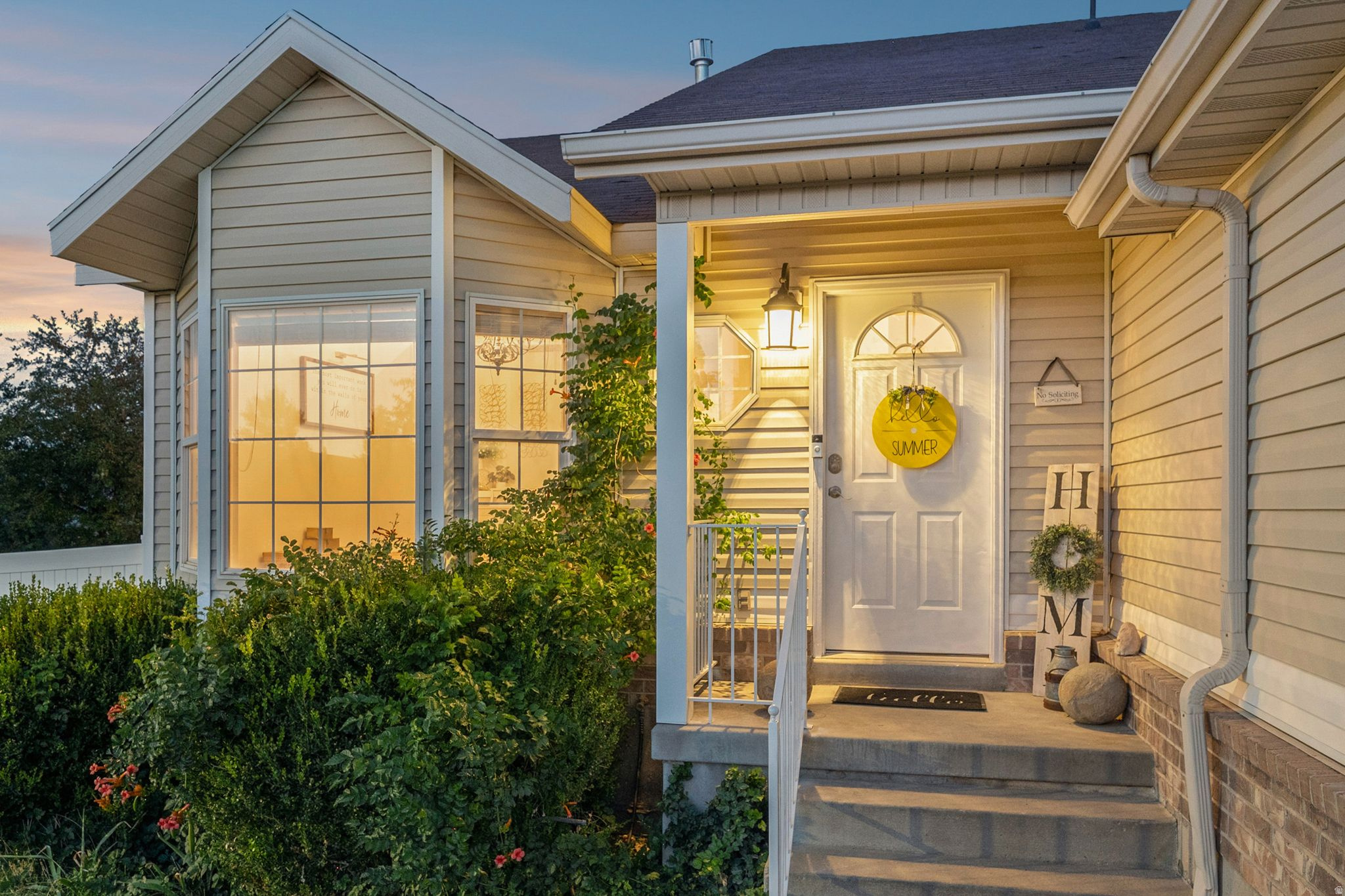 Exterior featuring horizontal siding, multiple windows, a front porch with steps, and an attached downspout system