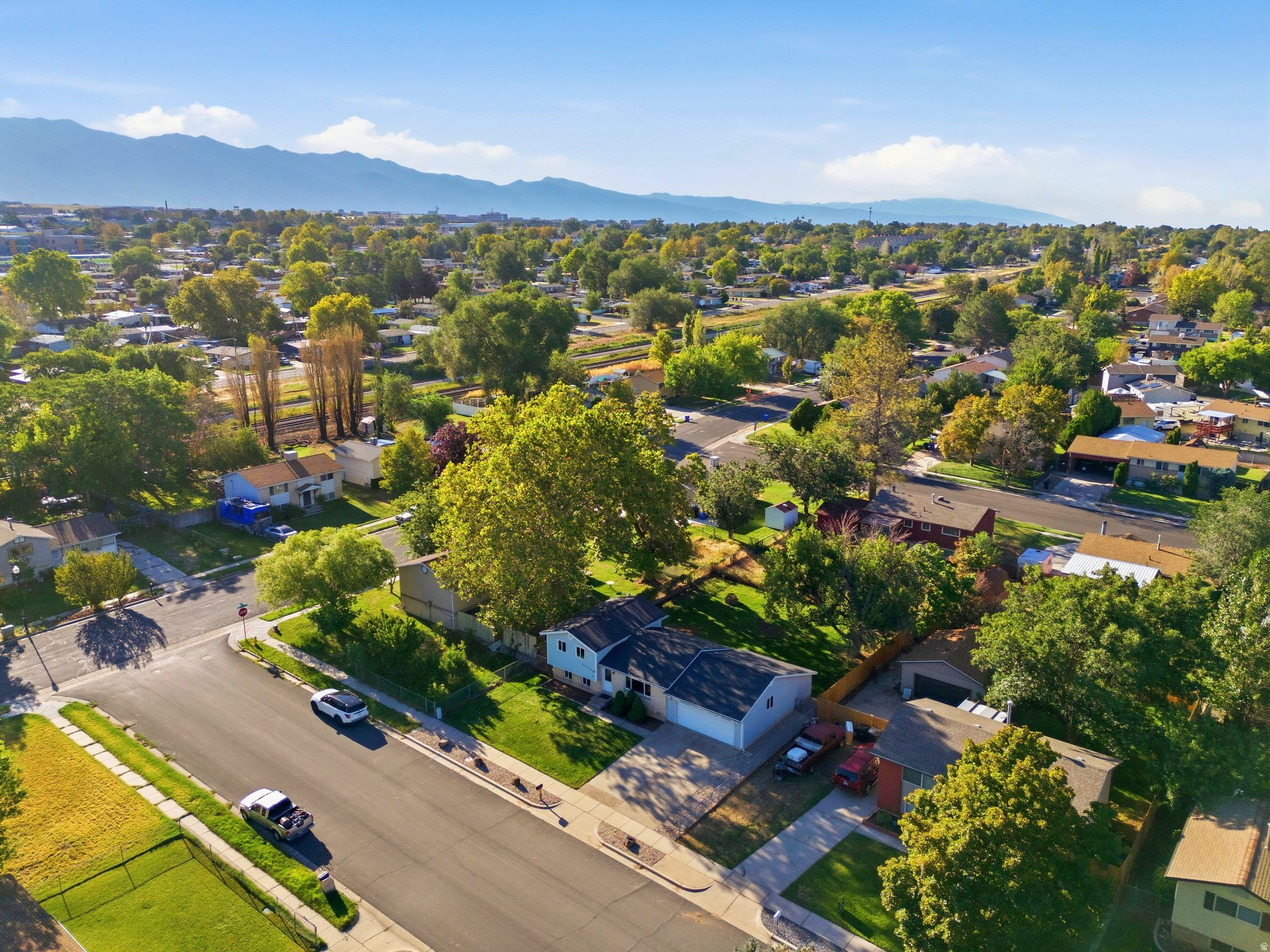 Expansive neighborhood featuring mature trees, residential streets, and distant mountains