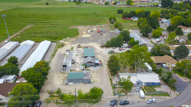 886 S 50 W Springville, Utah UNBELIEVABLE PROPERTY - 5.46 Acres!! Front Parcel #26-031-0063 (.75 Acres) is zoned R-1/ light industrial. Parcel # 26-028-0051 (4.73 Acres) in back (larger parcel see photos) is zoned as agricultural. Springville City is open to rezoning. There are 8 water shares and a.015 CFS well. The house and farmhouse are currently being rented out to 3 parties with a total income over $4000 a month! Property includes the additional acreage and outbuildings.