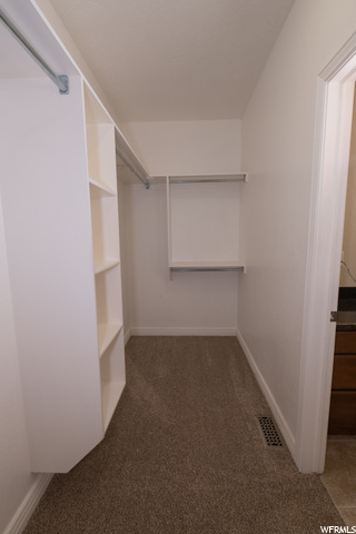 large walk in master closet with auto lighting